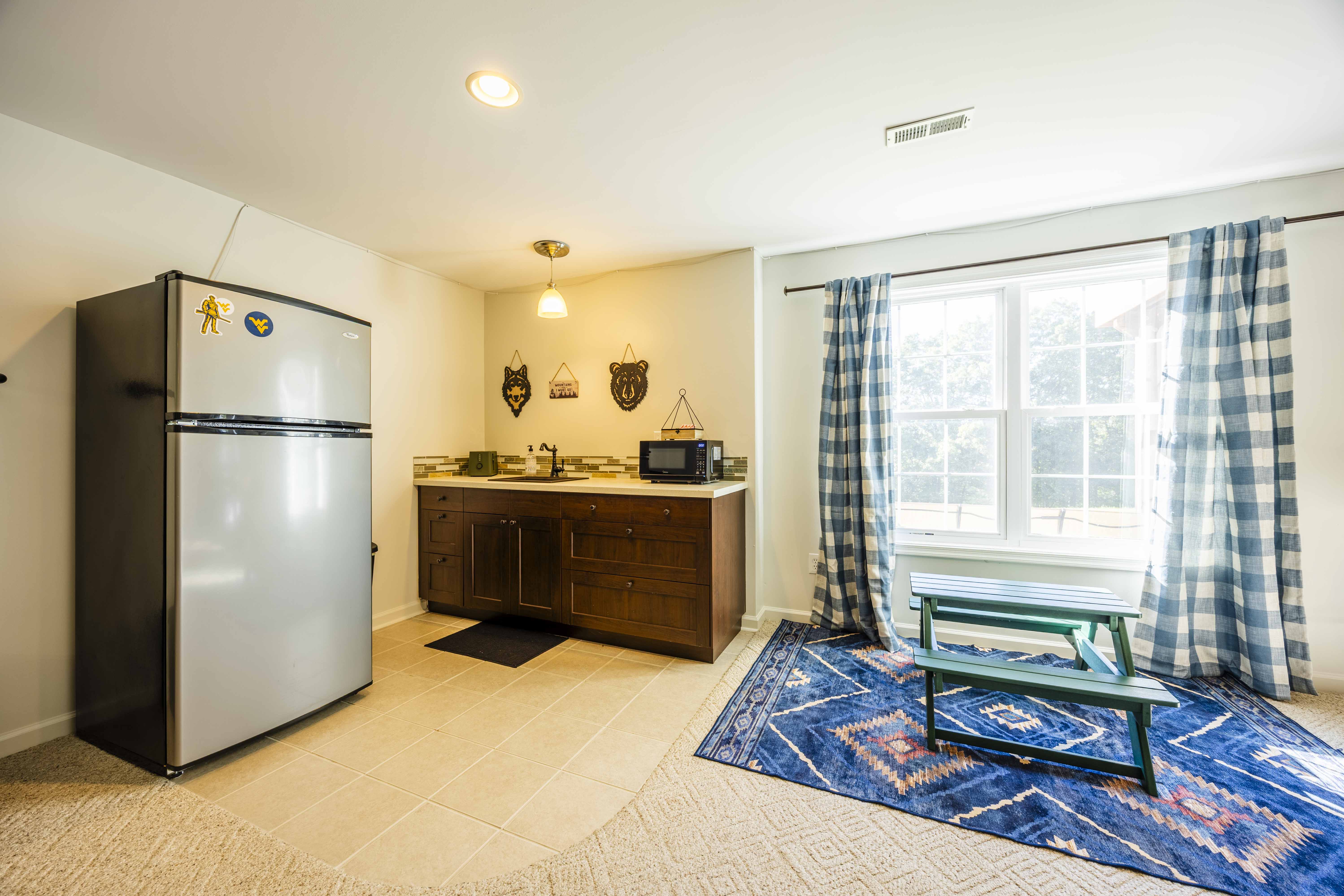 Bright kitchenette with full-size fridge, natural light, and cozy decor