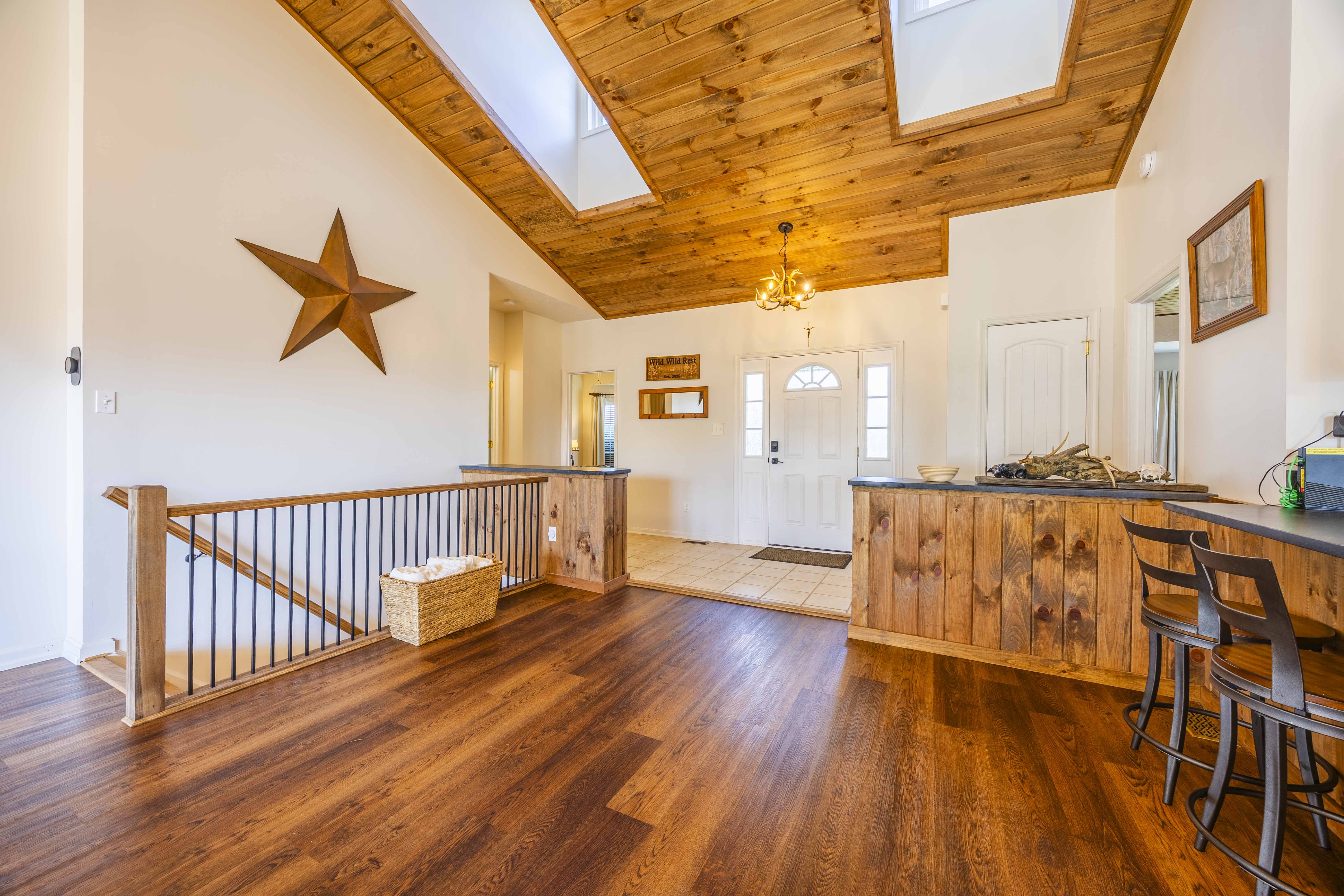 Bright rustic entry with skylights, vaulted wood ceilings, and bar seating