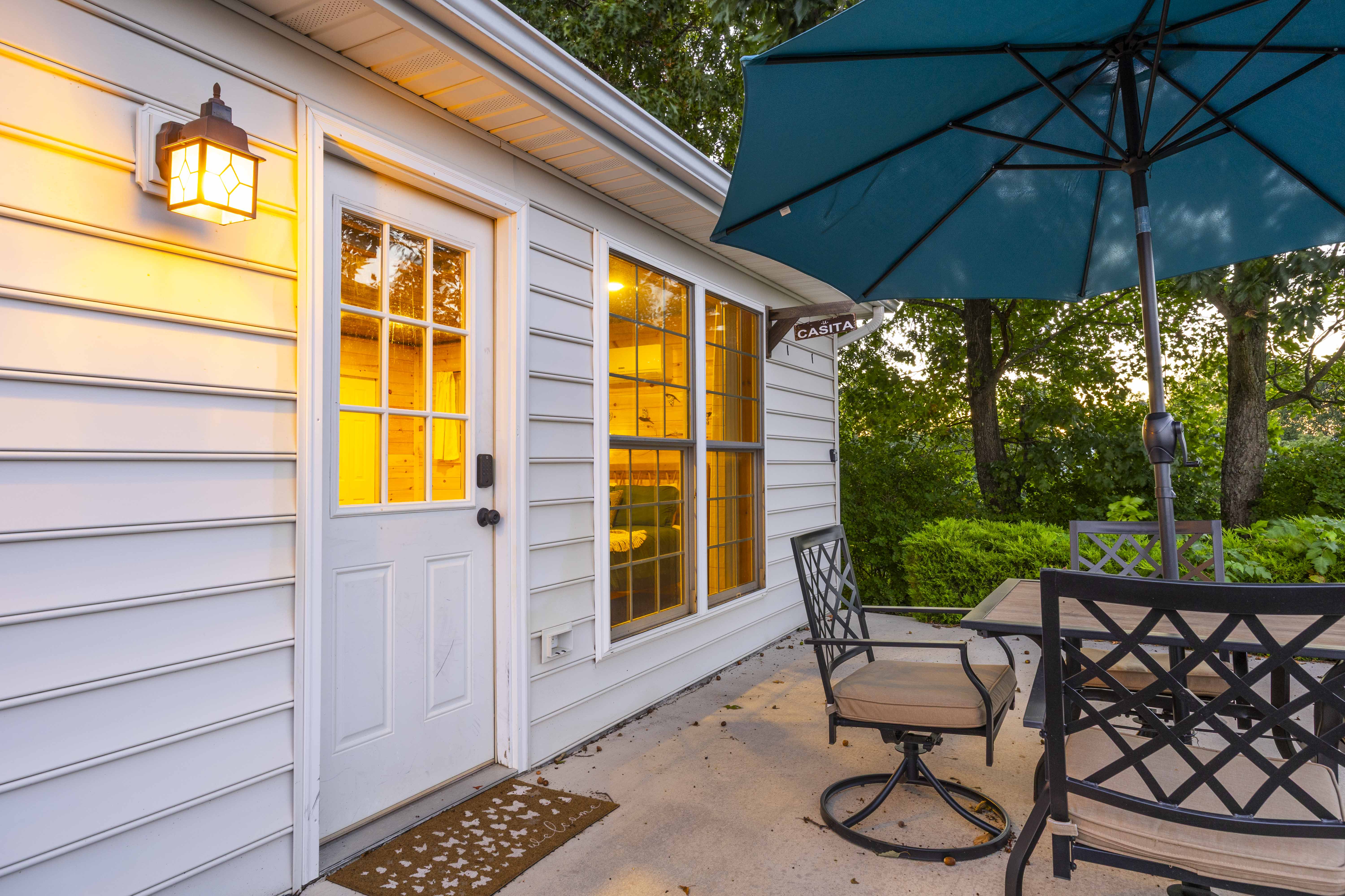 Private patio with umbrella dining and a warm, inviting entry