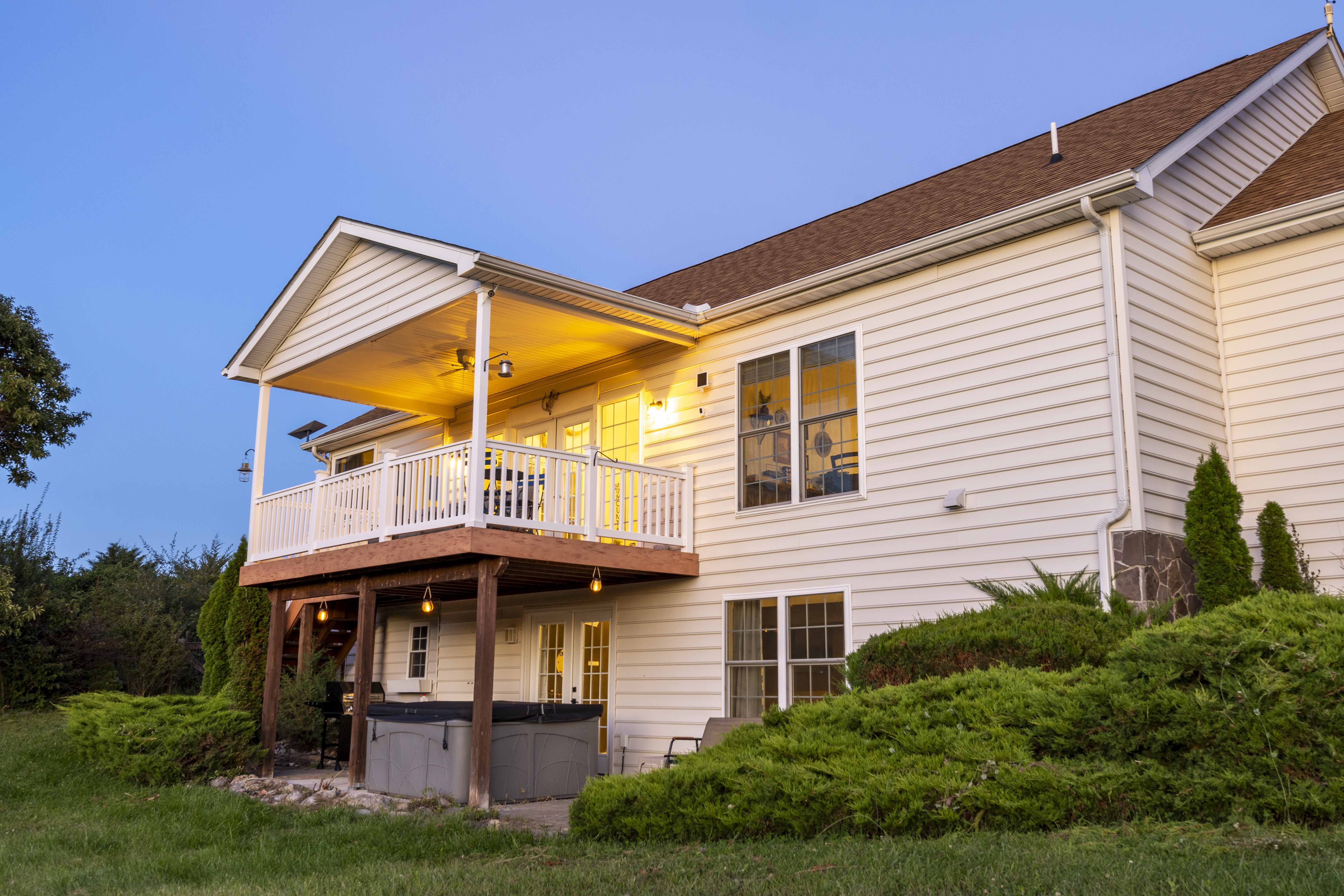 Inviting covered deck and private hot tub with peaceful yard views
