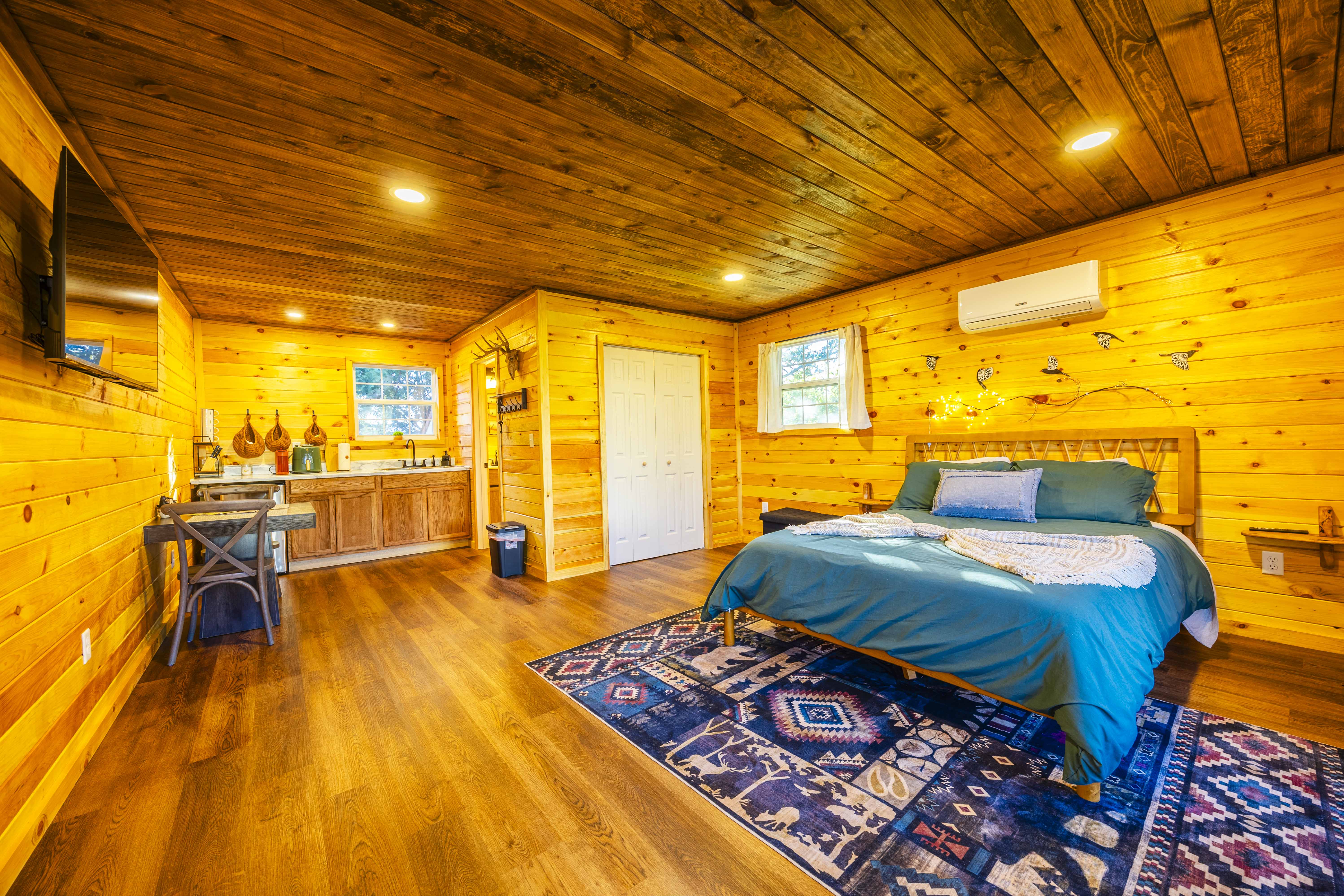 Cozy wood cabin suite with queen bed, kitchenette, and rustic charm