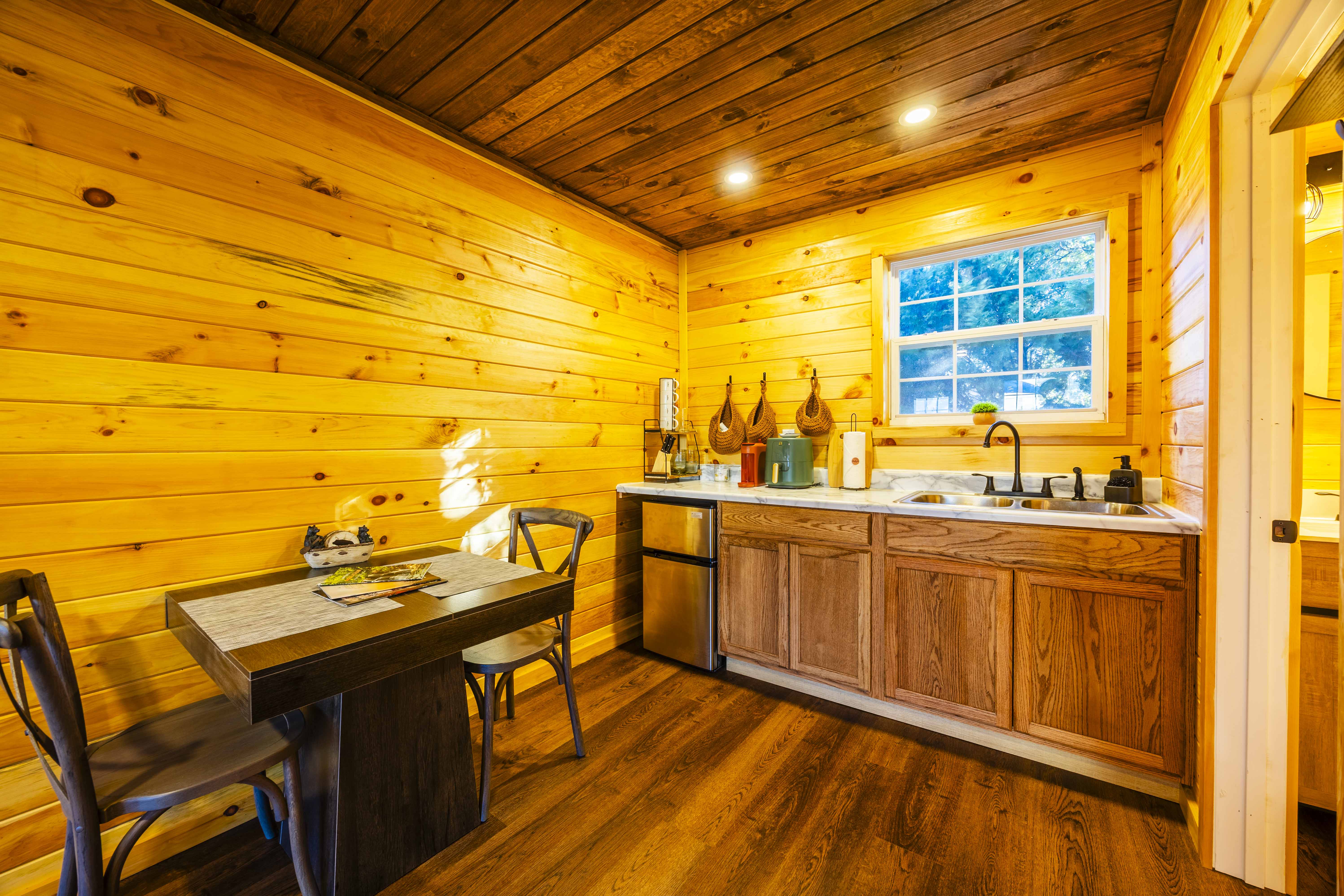 Cozy cabin kitchenette with dining nook and warm rustic wood accents