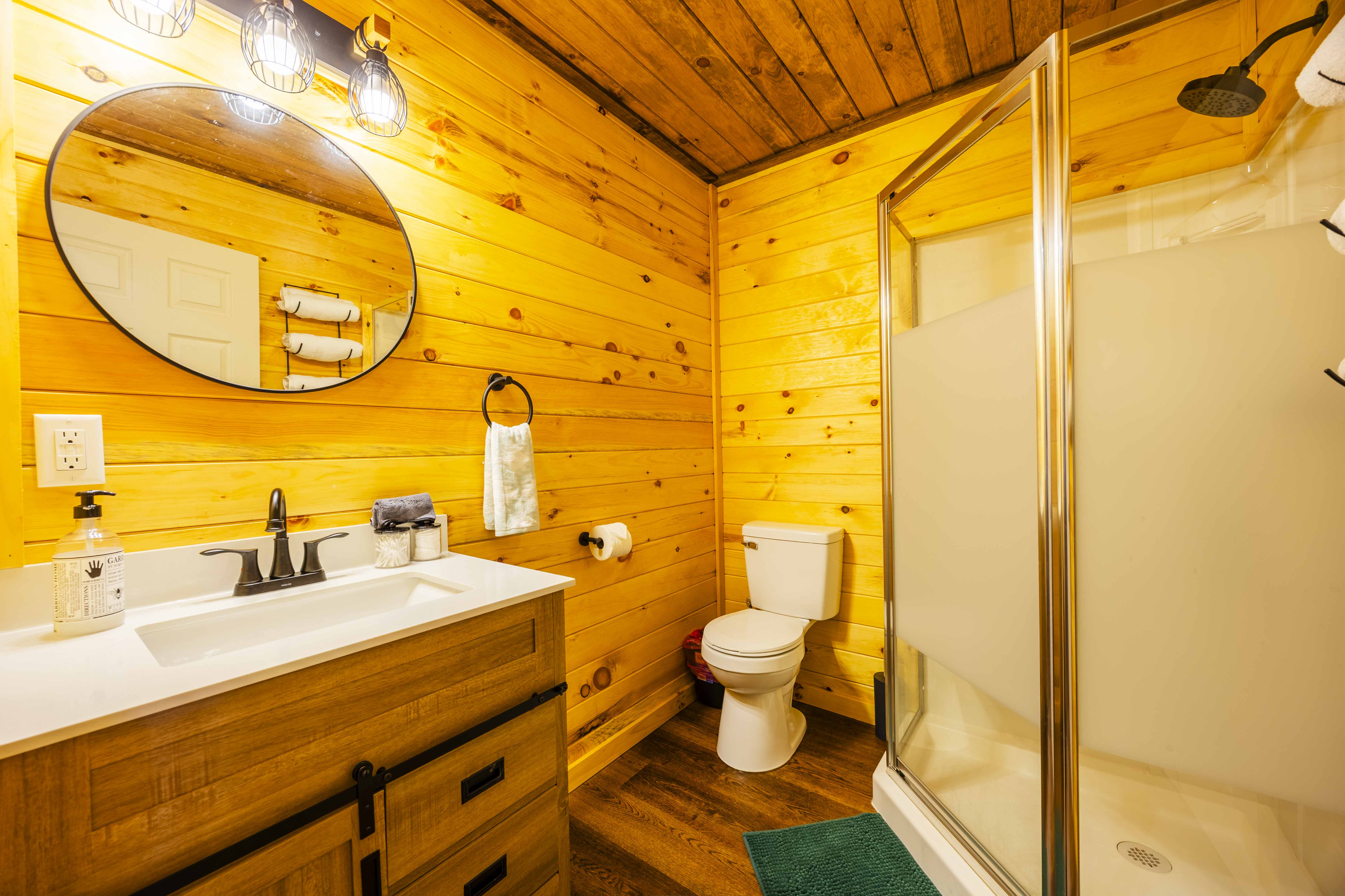 Cozy cabin-style bathroom with modern vanity and glass walk-in shower