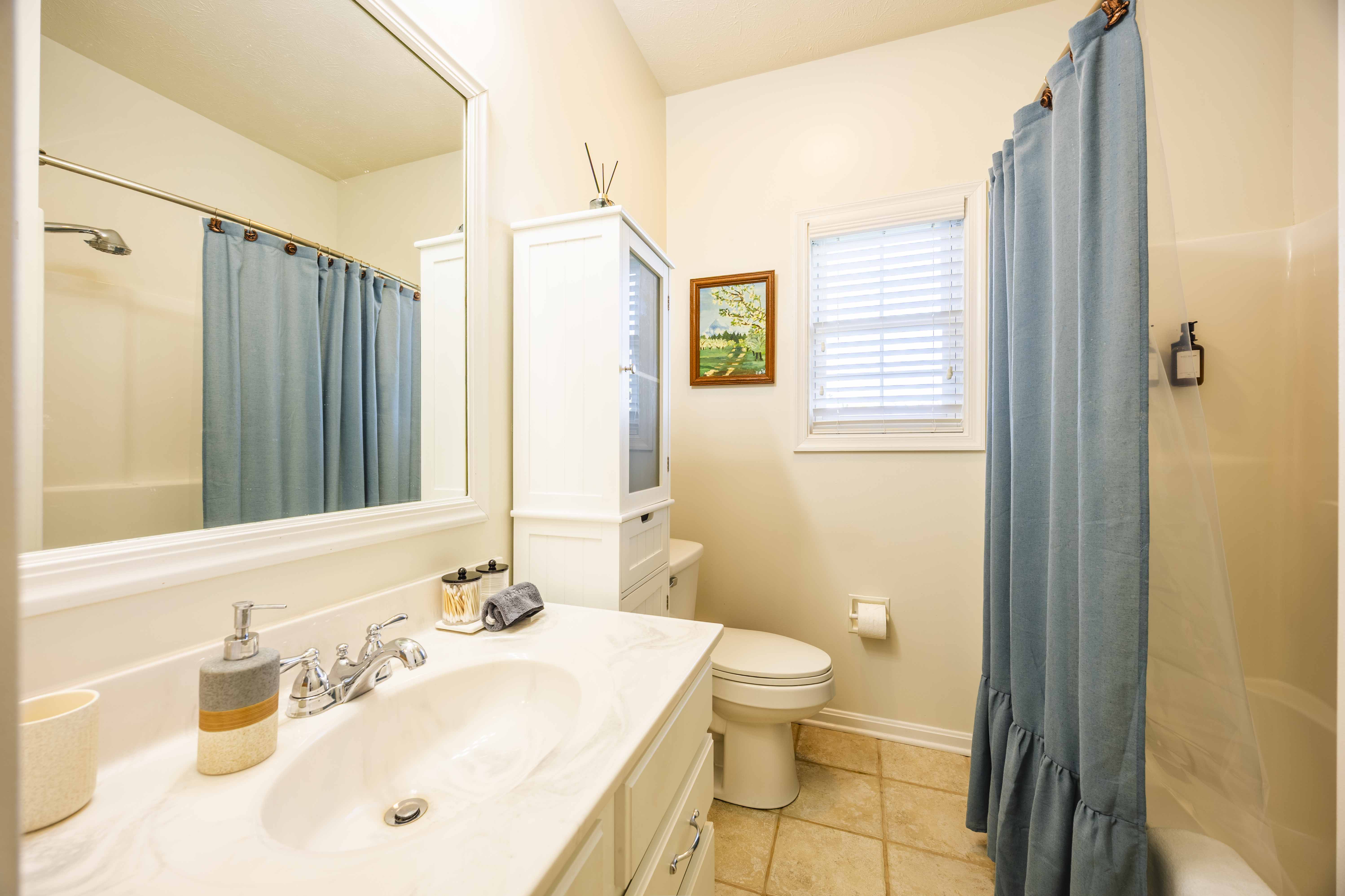 Bright, spotless bathroom with roomy vanity and tub-shower combo