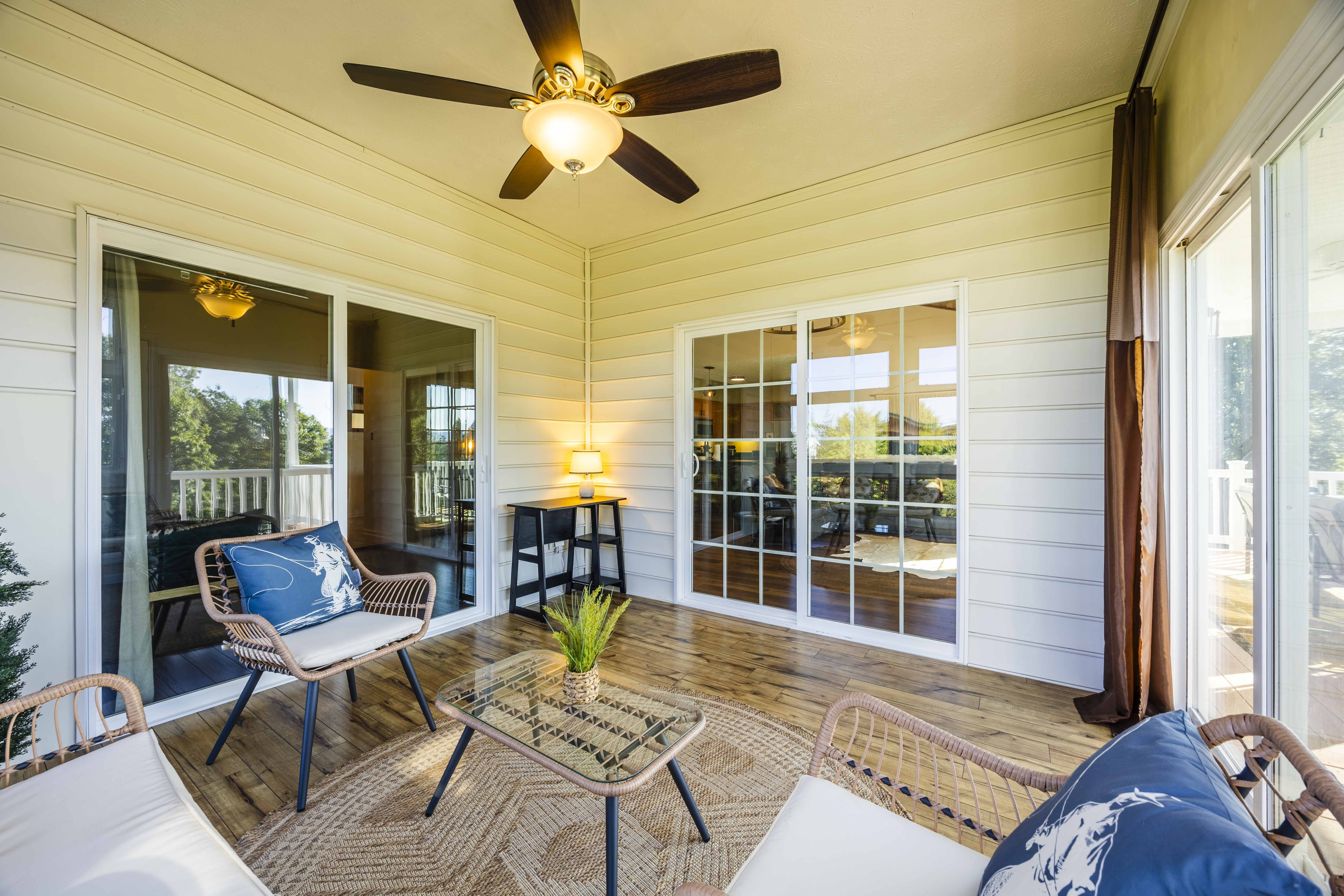 Covered patio with cozy seating, ceiling fan, and bright indoor-outdoor flow