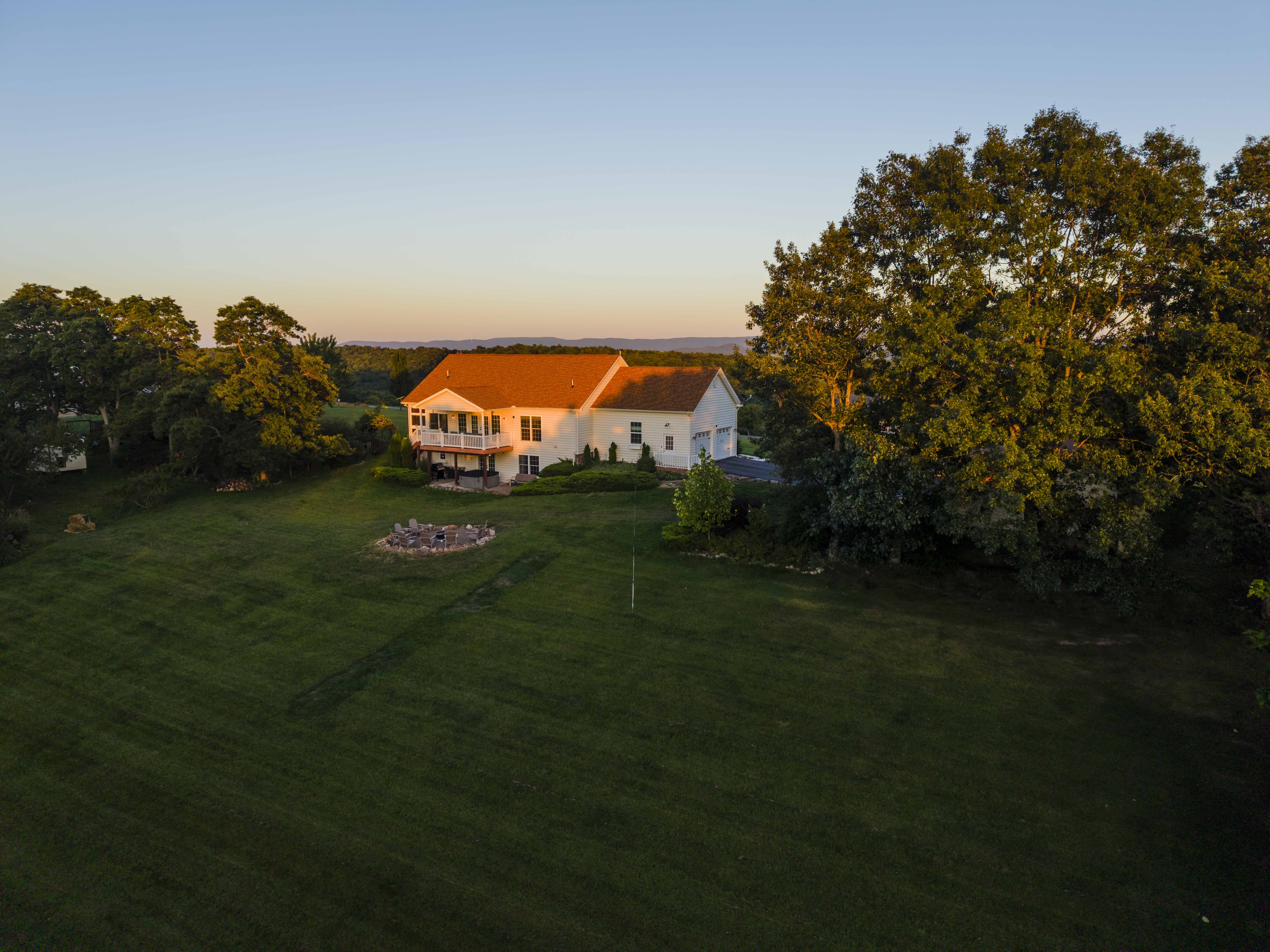 Peaceful country home with expansive lawn, sunset views, and fire pit
