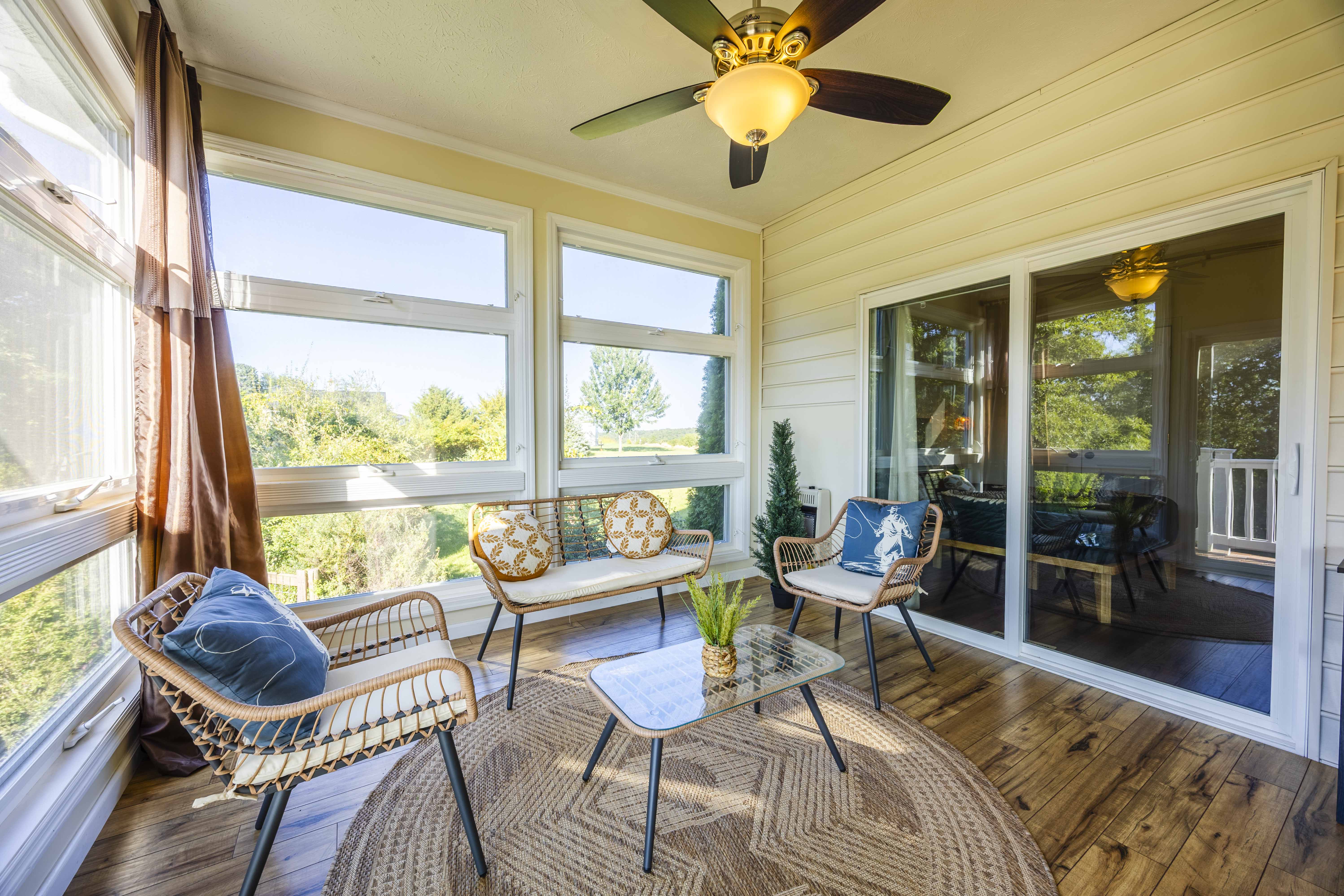 Sunny enclosed porch with cozy seating and serene nature views
