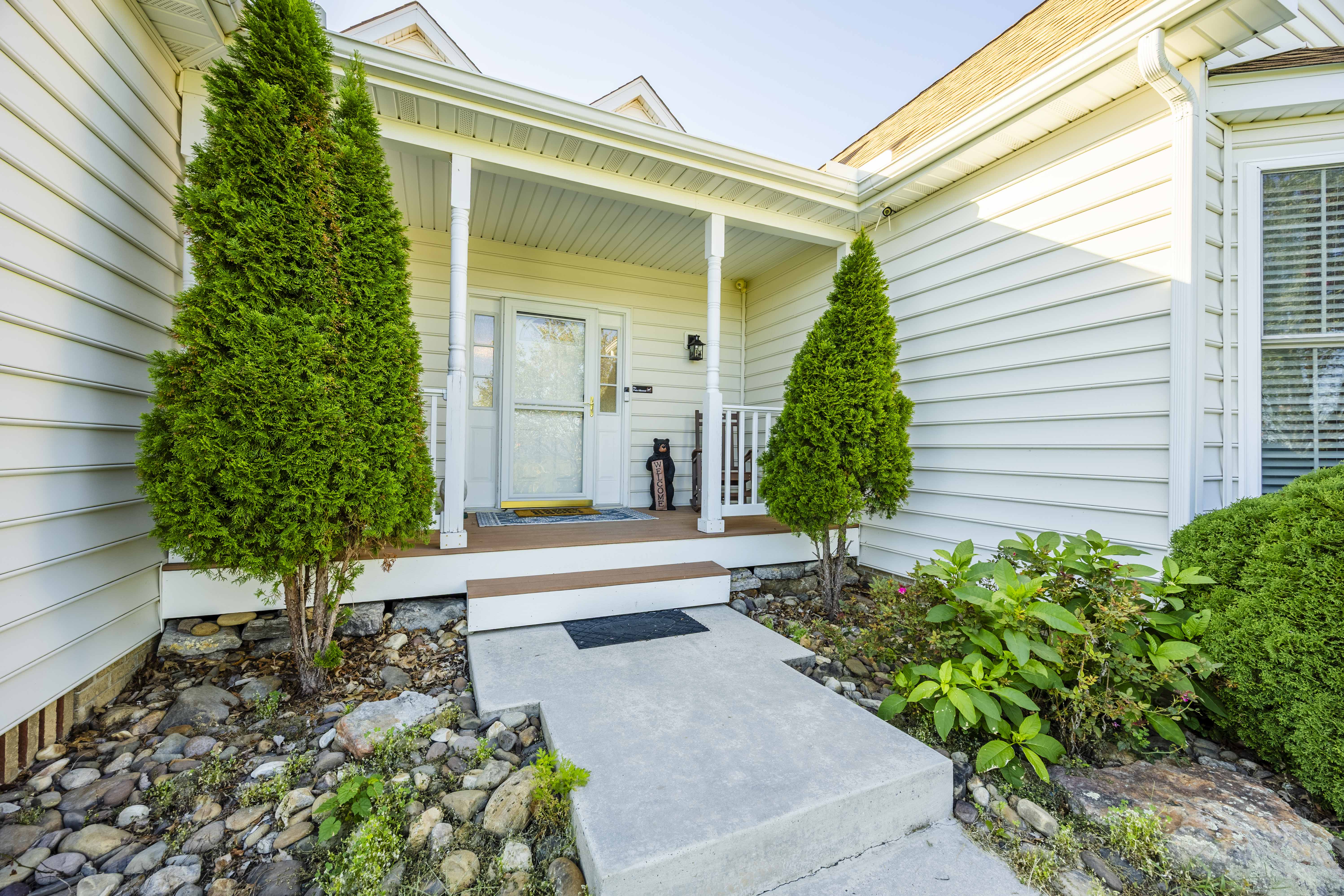 Welcoming covered front porch with charming landscaping