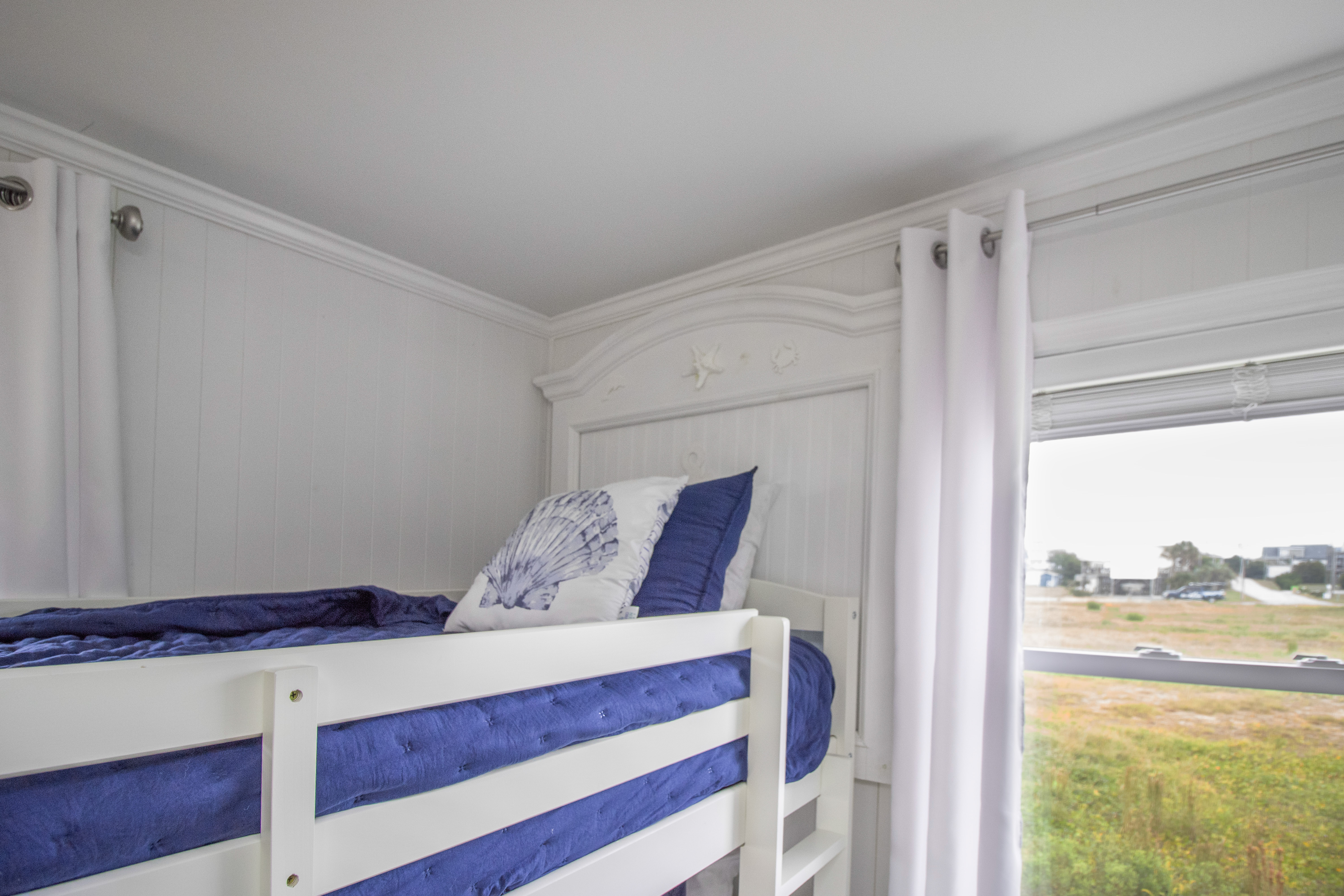 Bright coastal bunk room with blue accents and natural light