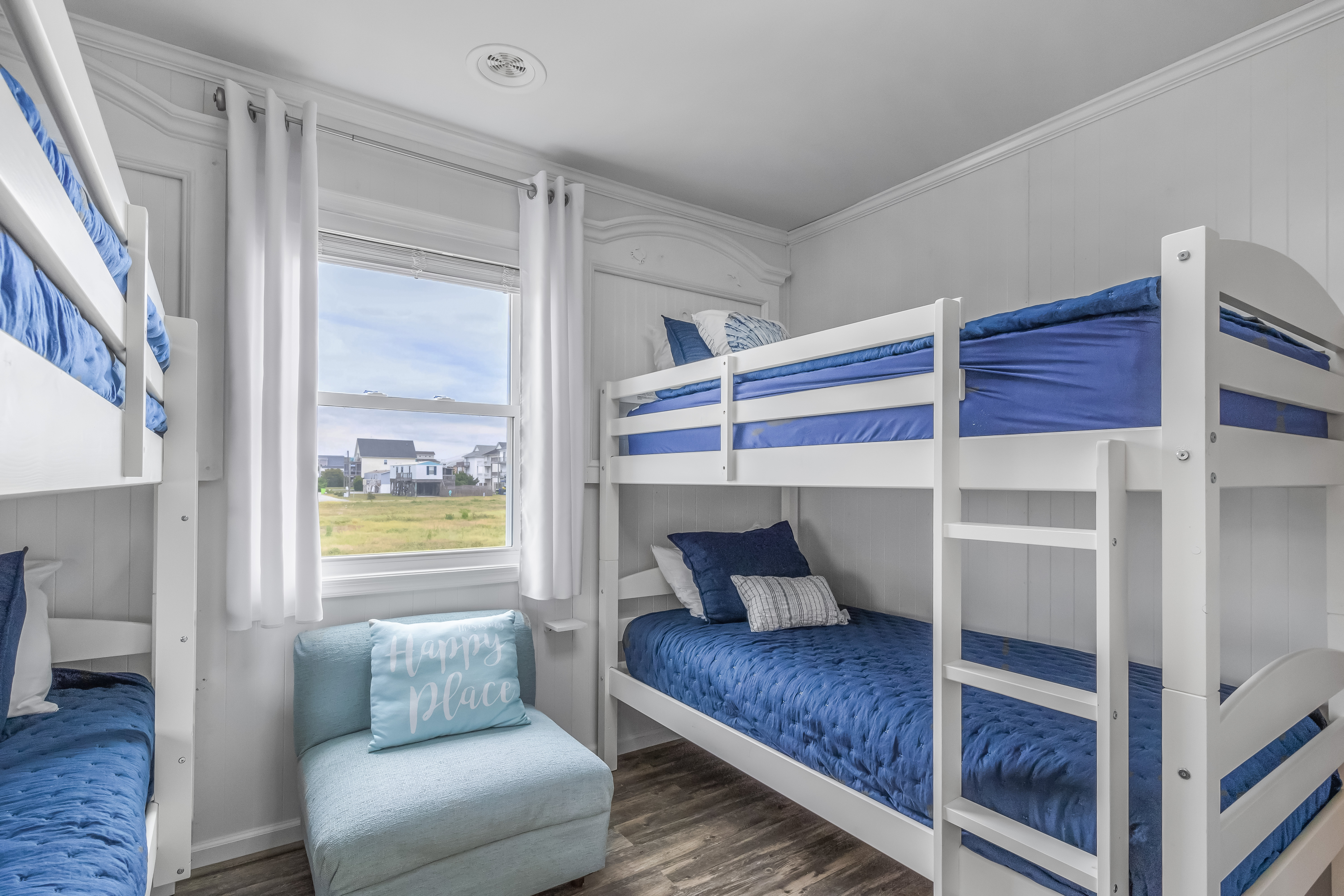 Bright bunk room with comfy blue bedding and space for the whole crew