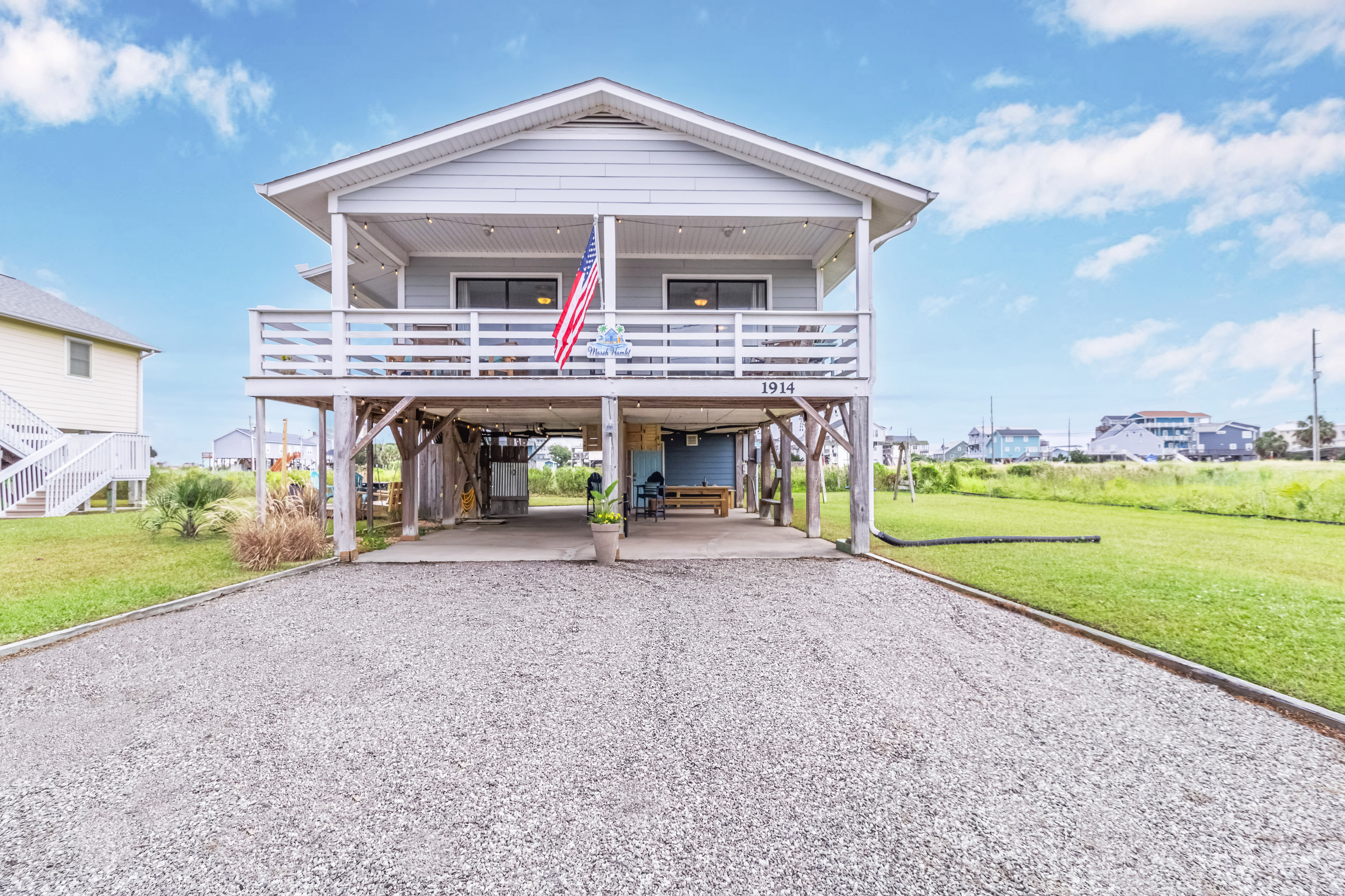 Elevated beach home with covered porch, parking, and spacious yard
