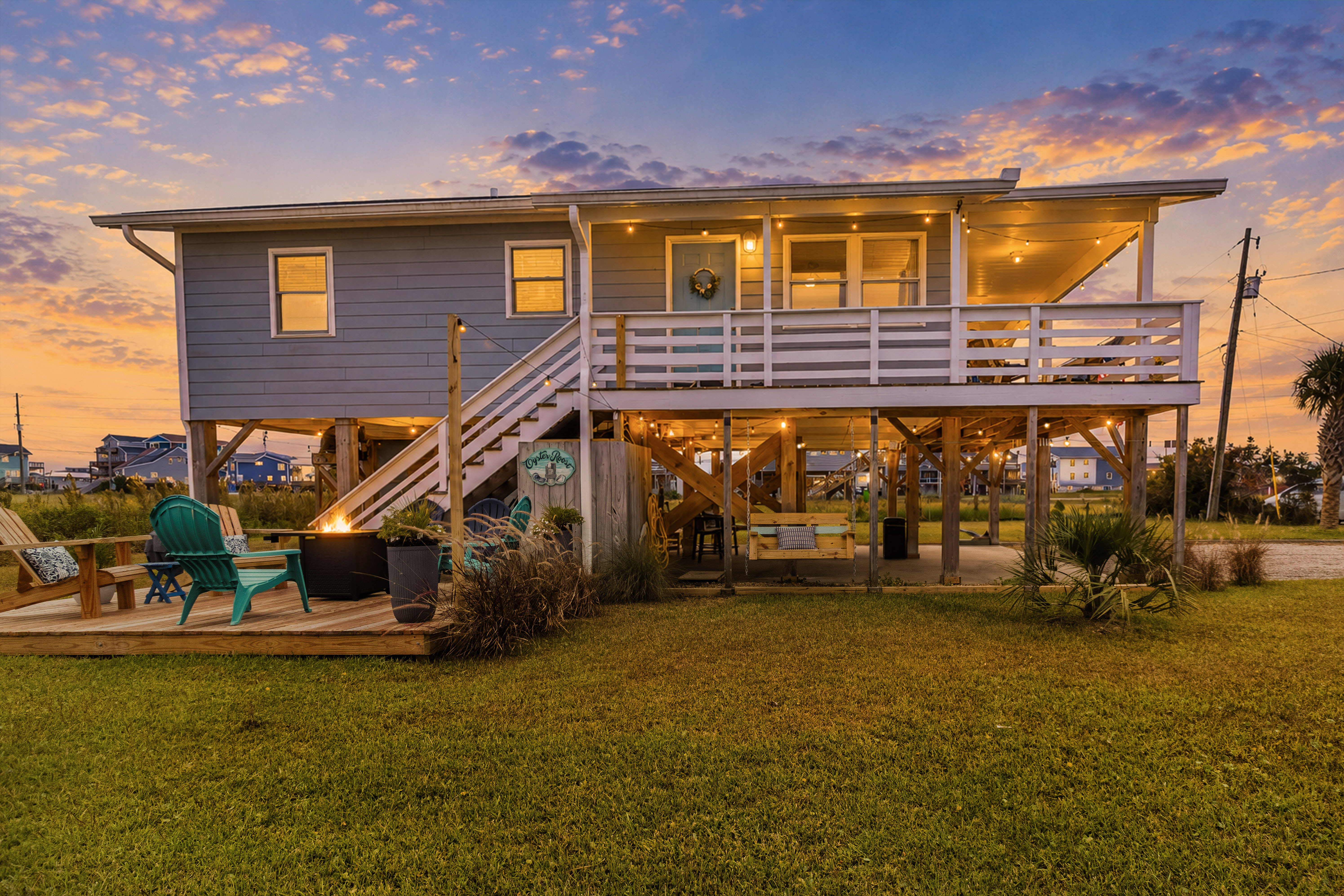 Charming elevated beach home with deck, yard, and glowing sunset views