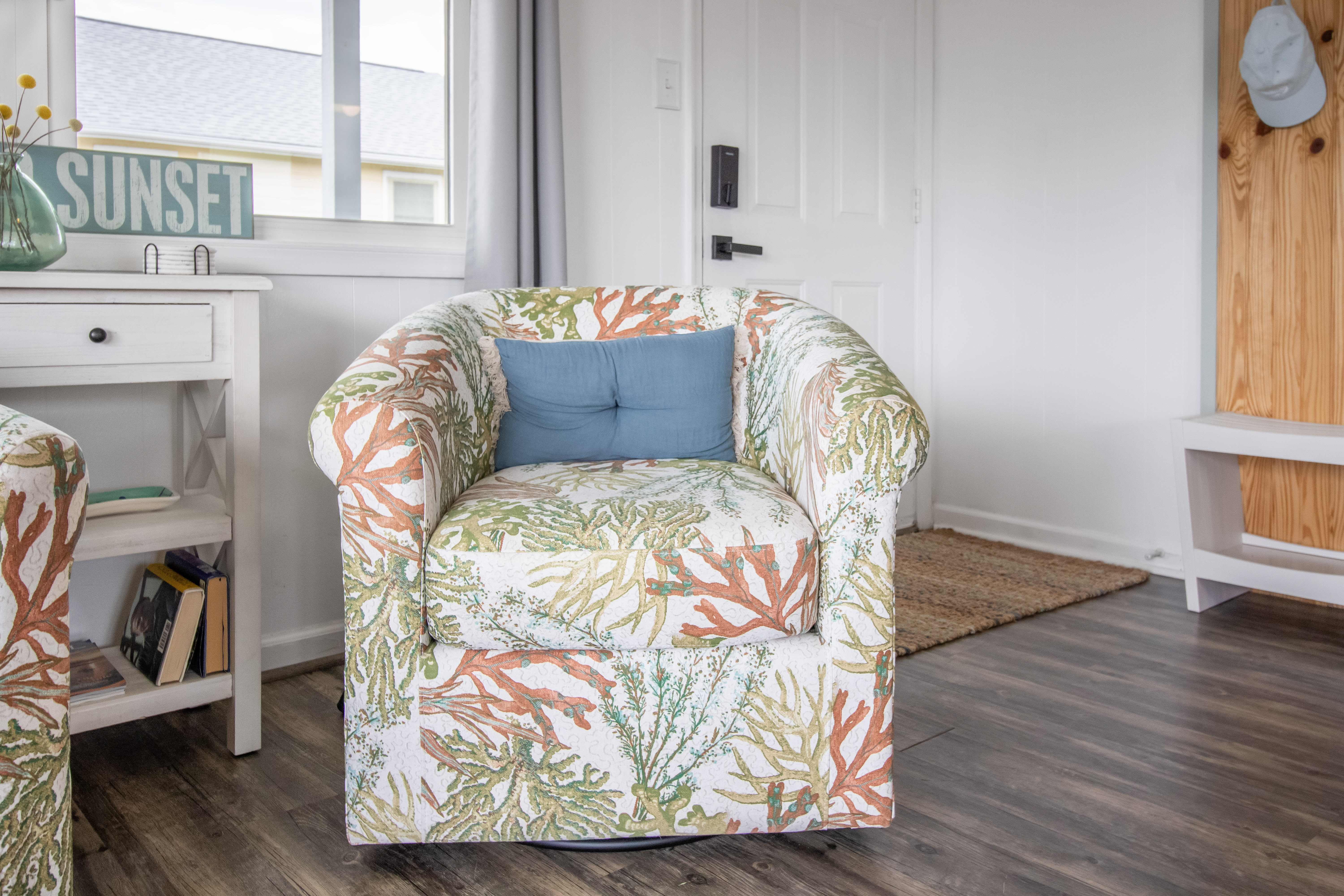 Coastal-style reading nook with bright light and cheerful coral-print seating