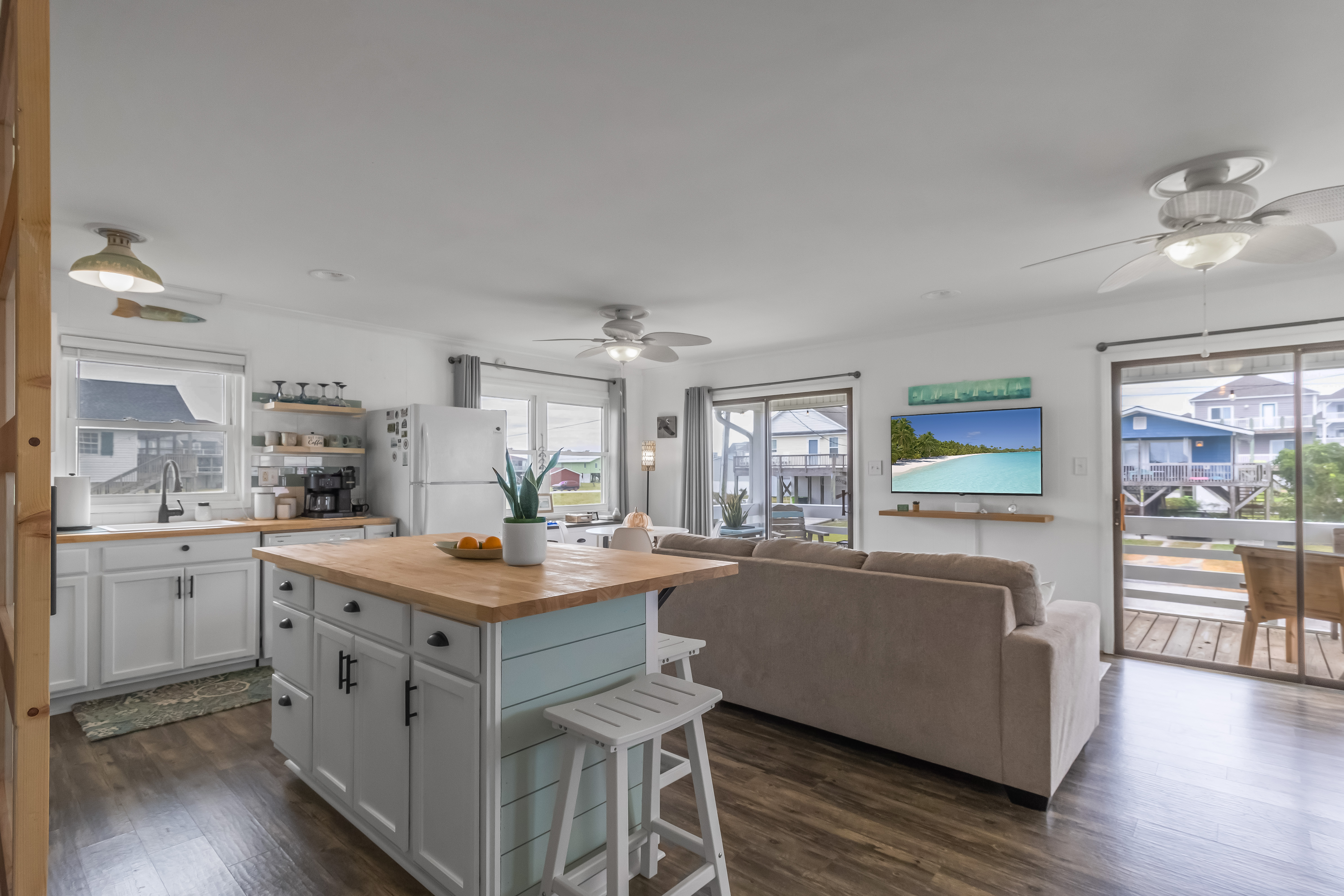 Bright open living space with island seating and easy deck access