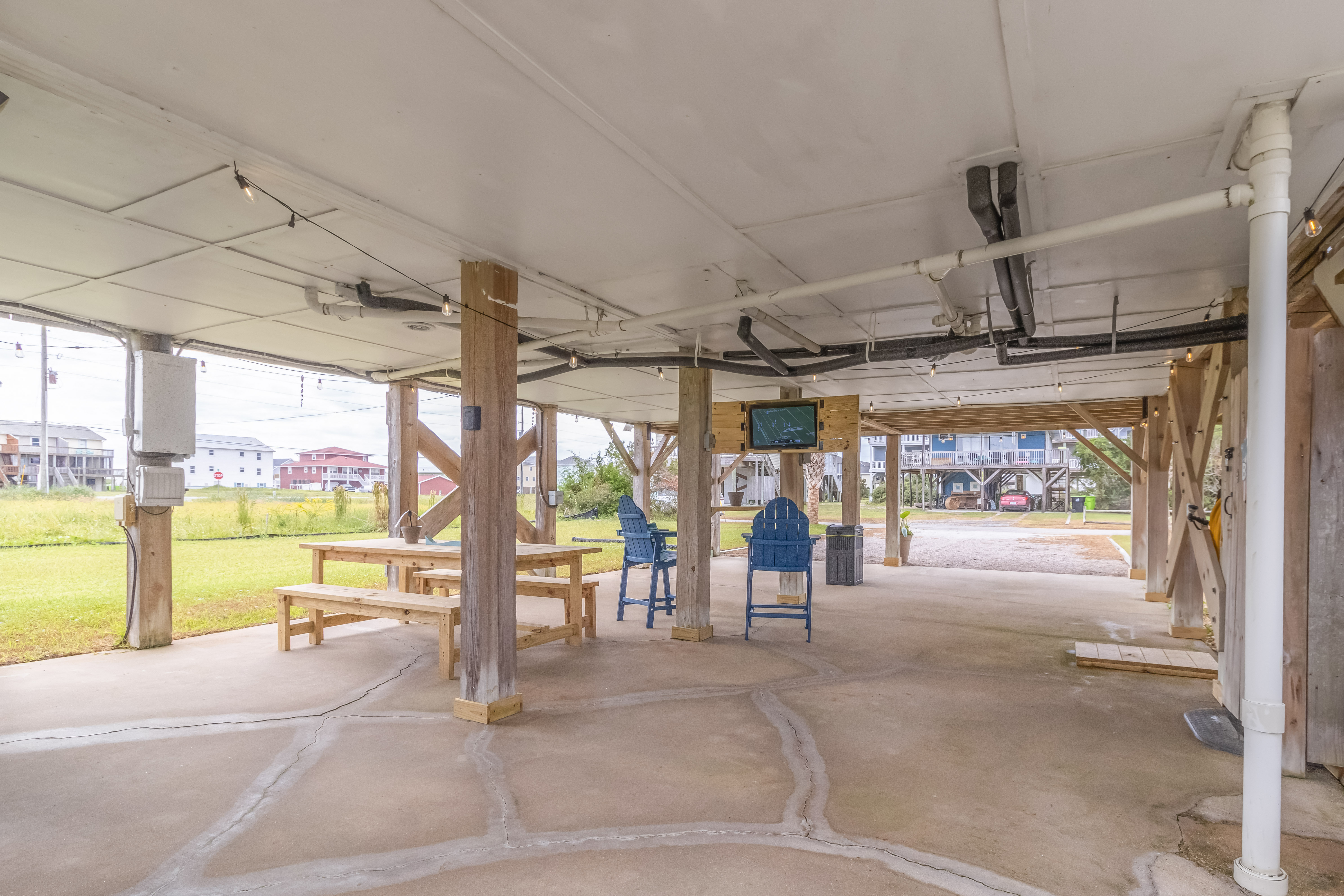Spacious covered hangout area with picnic table, TV, and ample parking