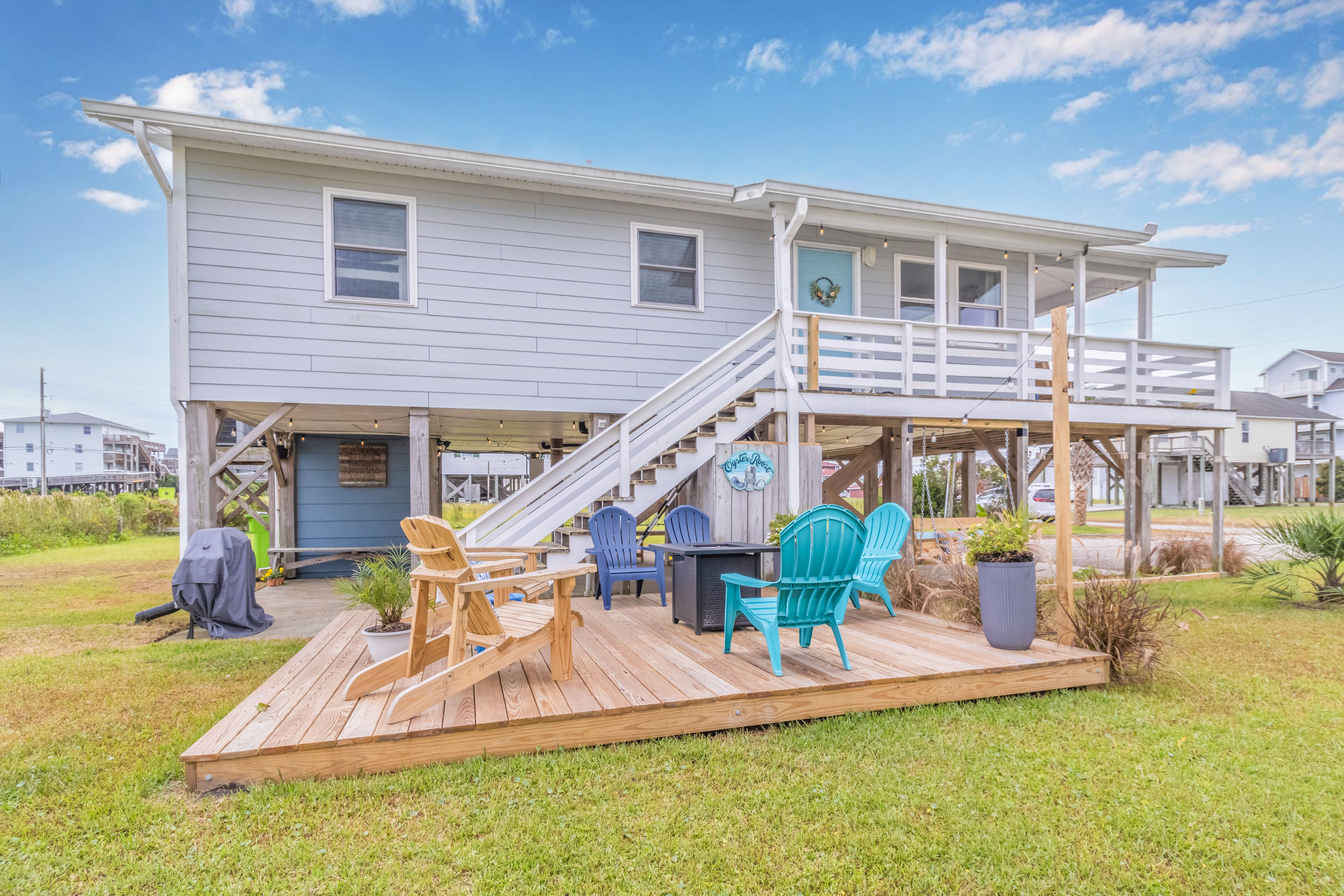 Relax beneath the beach house with fire pit seating and coastal charm