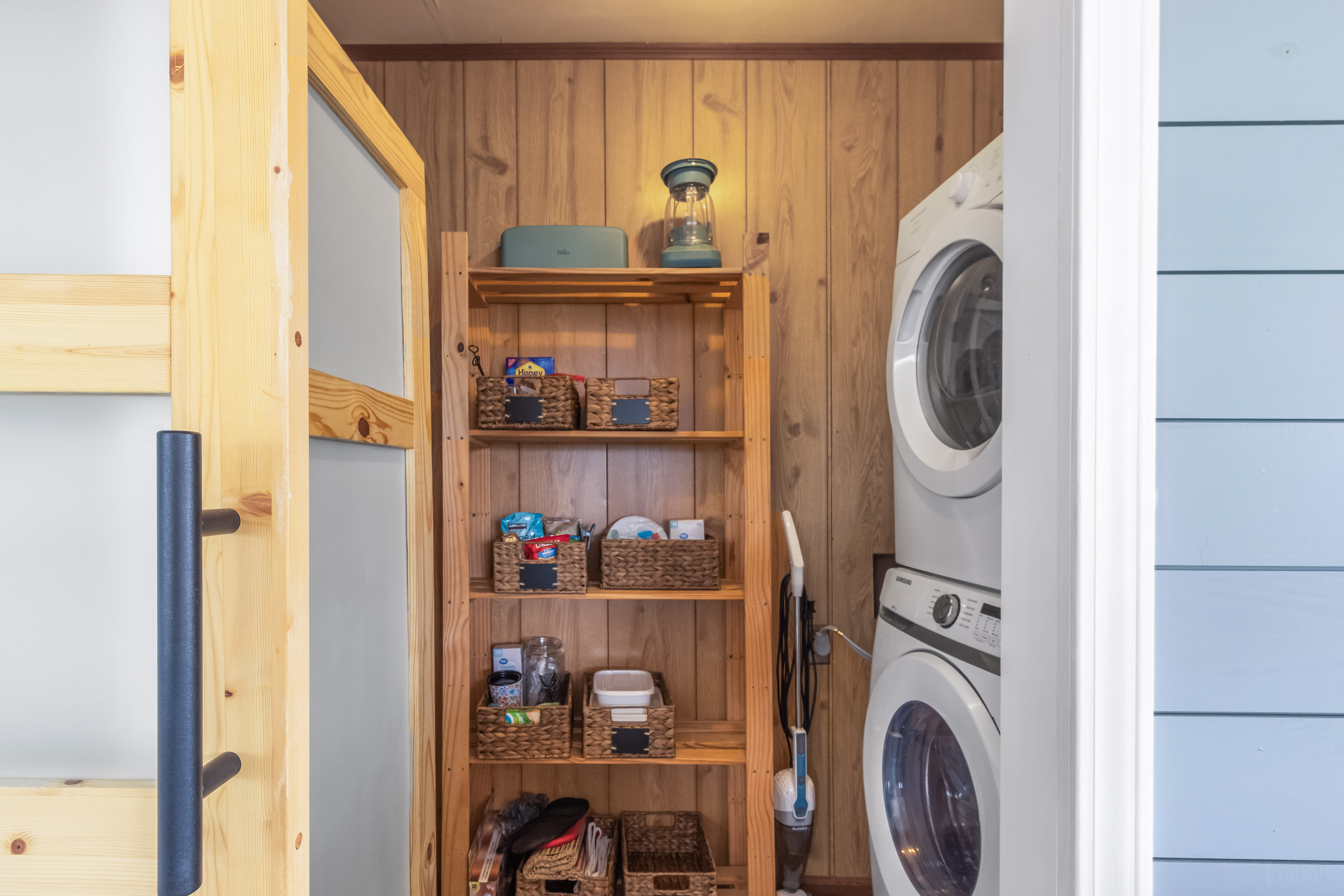 Cozy laundry nook with stacked washer/dryer and organized guest essentials