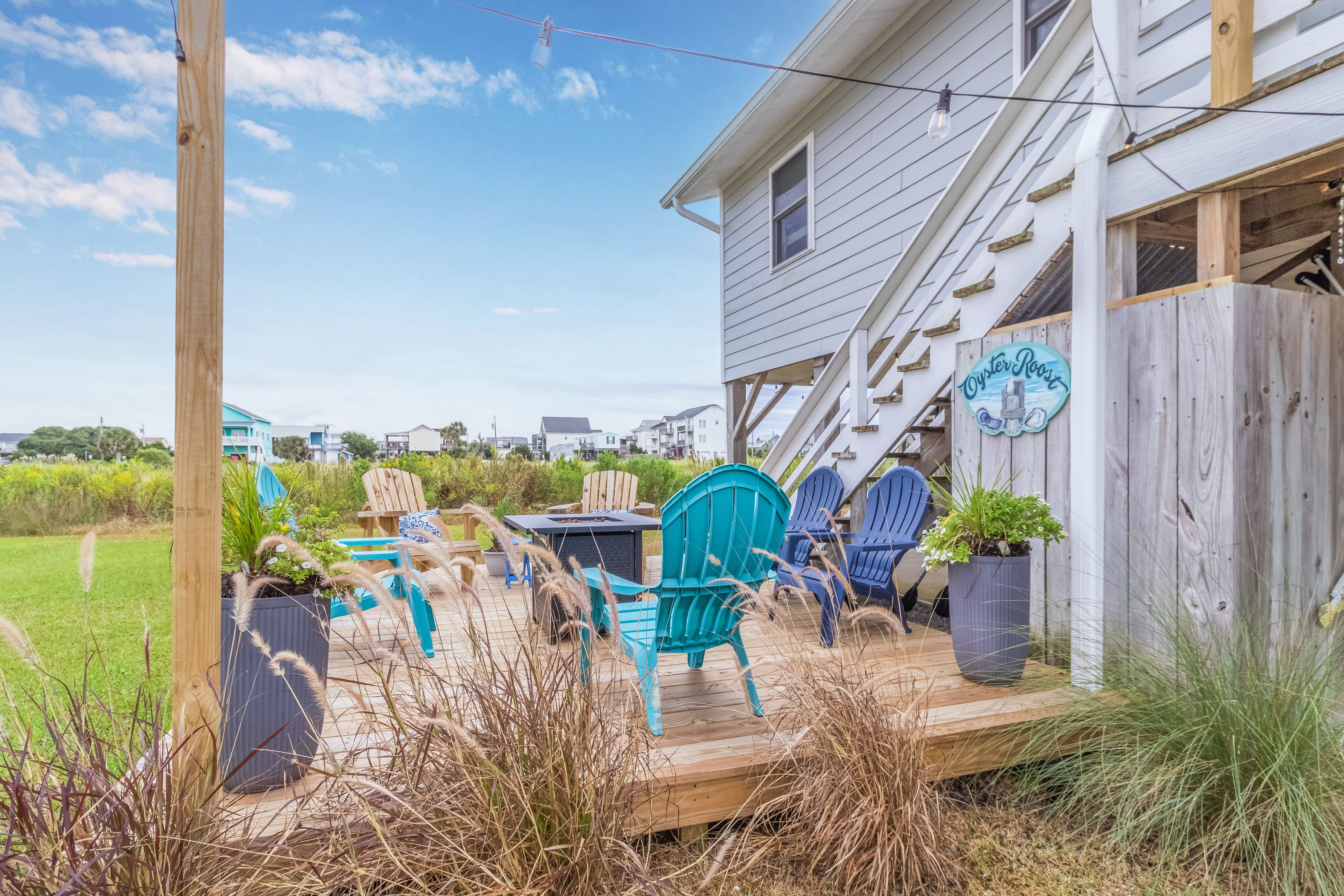 Relax on the coastal deck with Adirondack chairs and fire pit seating