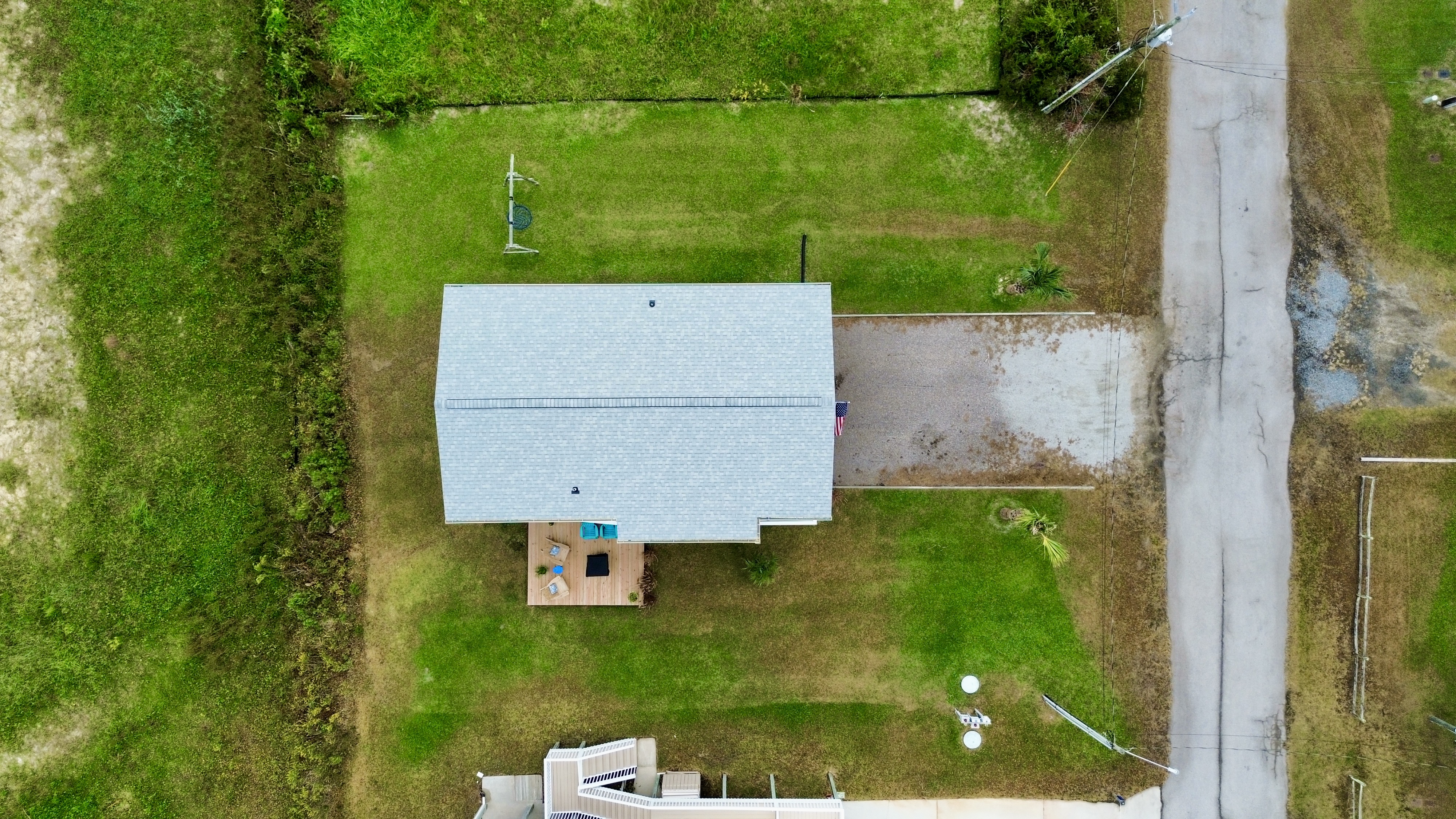Aerial view with spacious yard, private driveway, and cozy outdoor deck