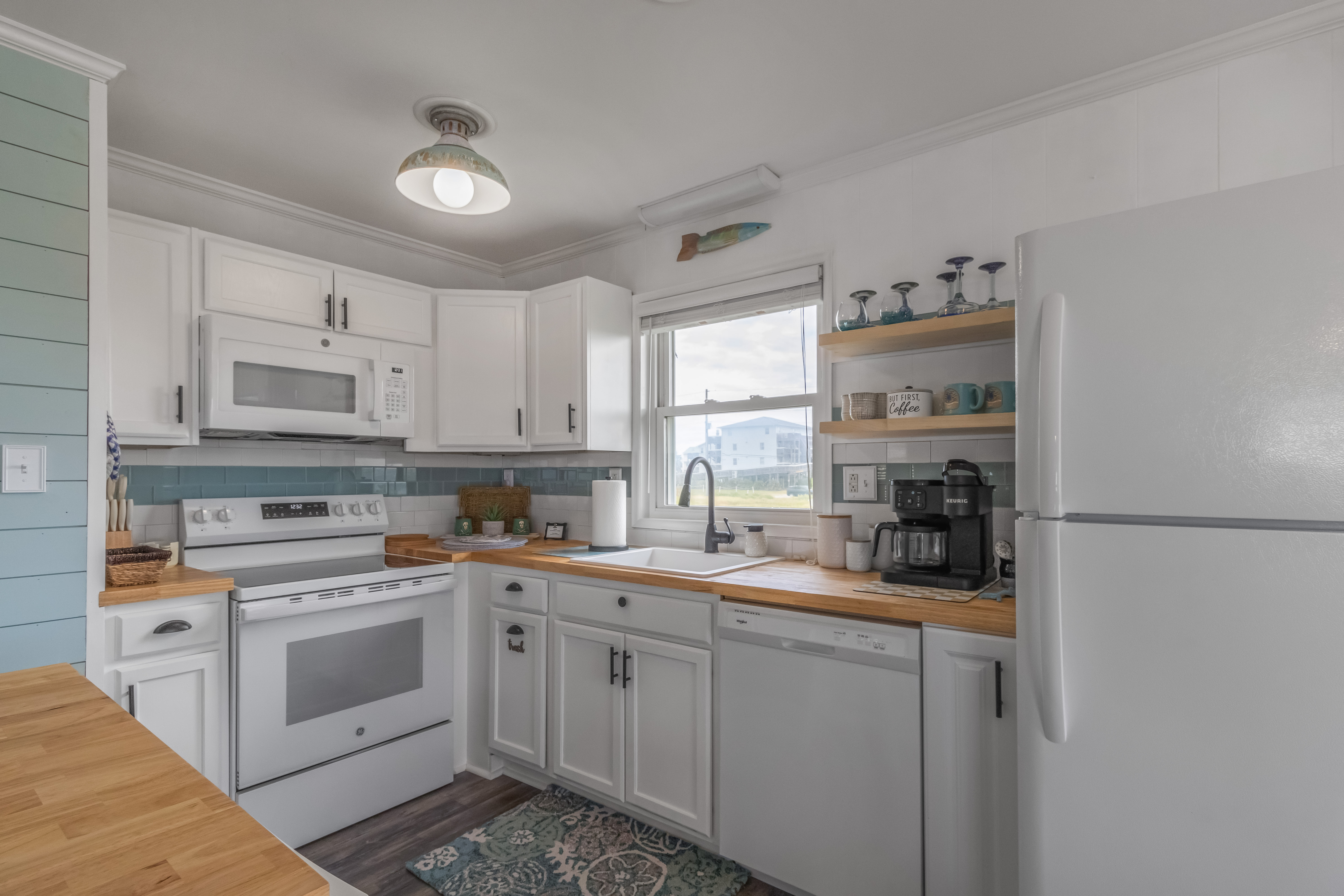 Bright coastal kitchen with butcher block counters and sunny coffee station