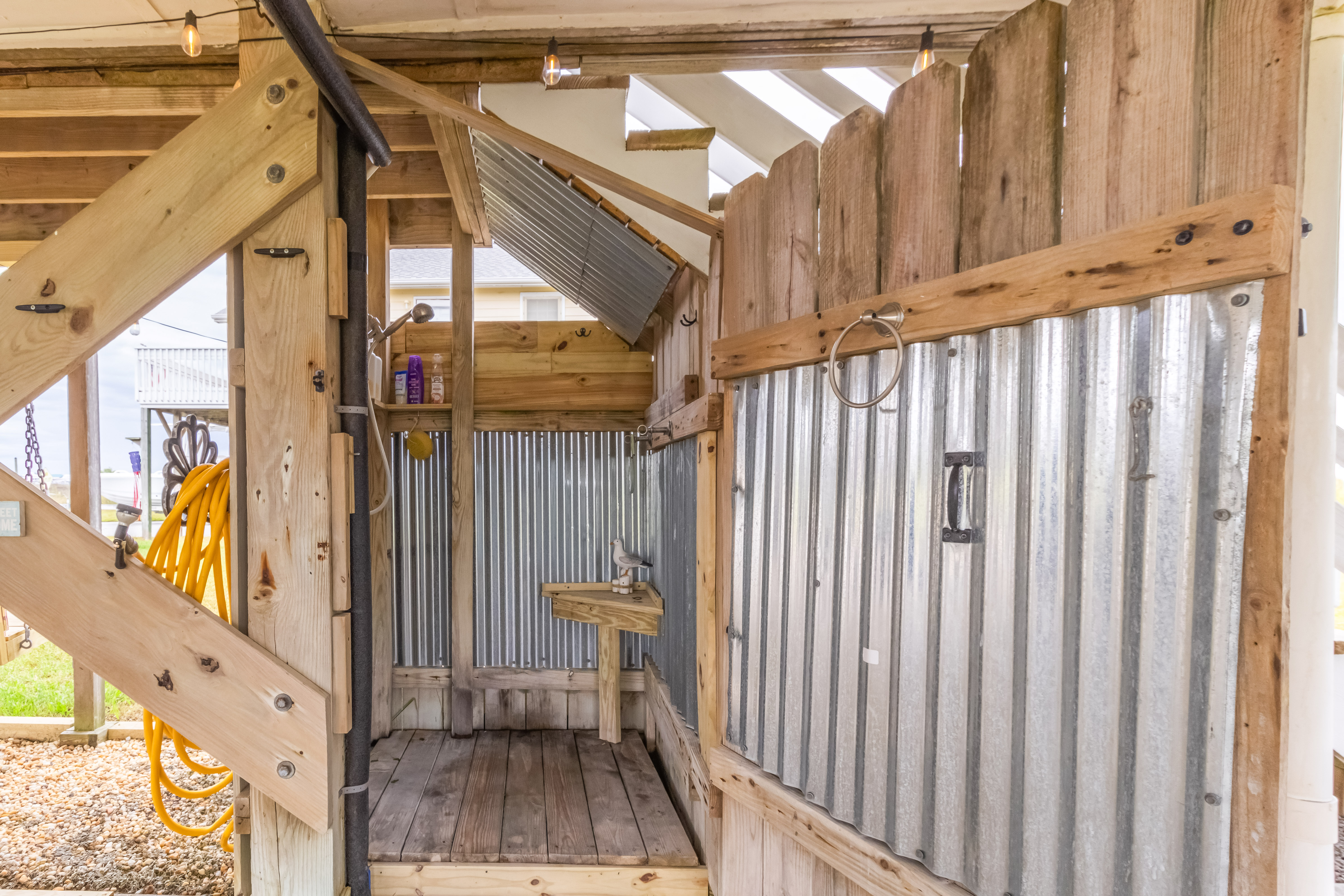 Rustic open-air outdoor shower with farmhouse charm and handy sink