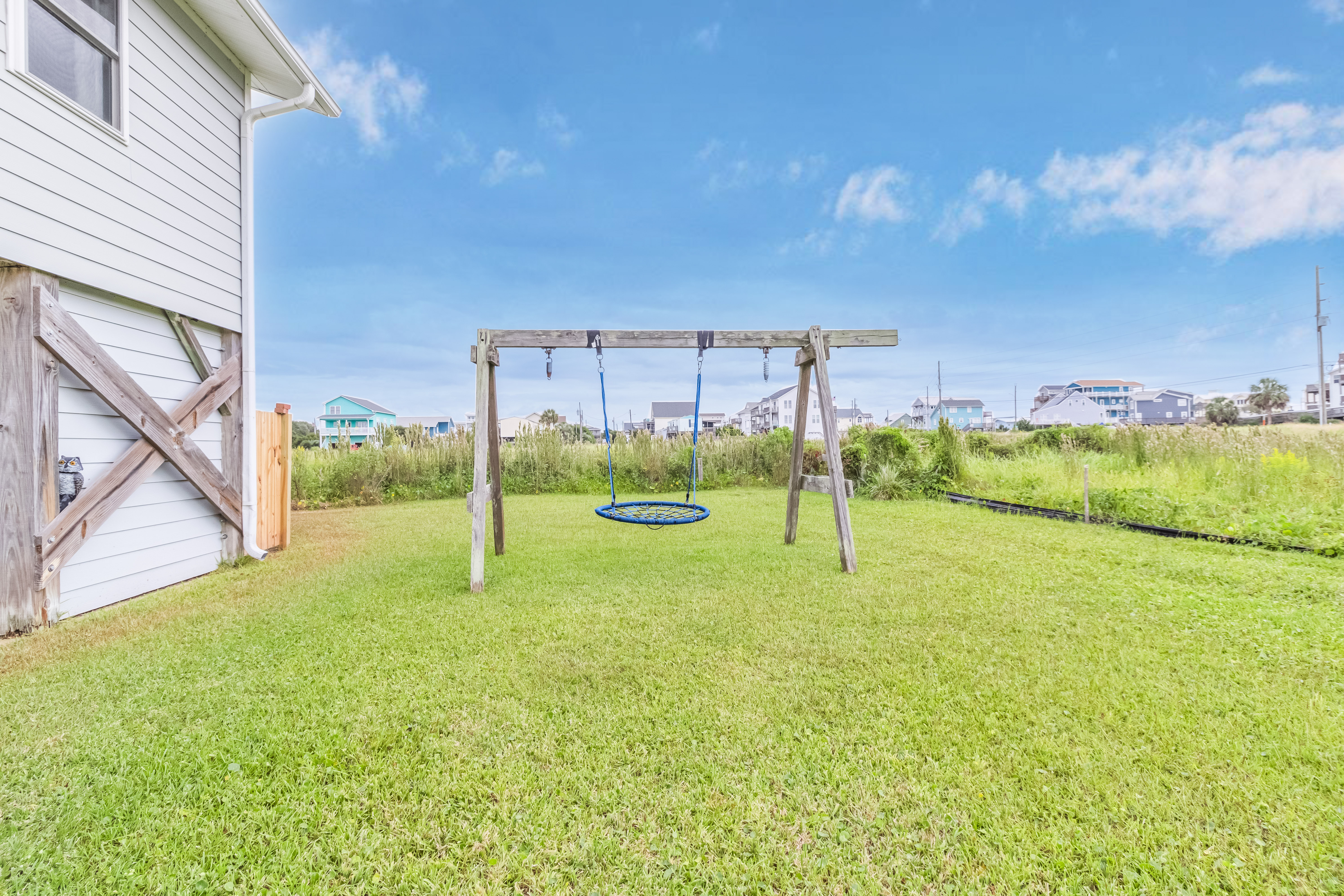 Spacious backyard with play swing and open coastal views