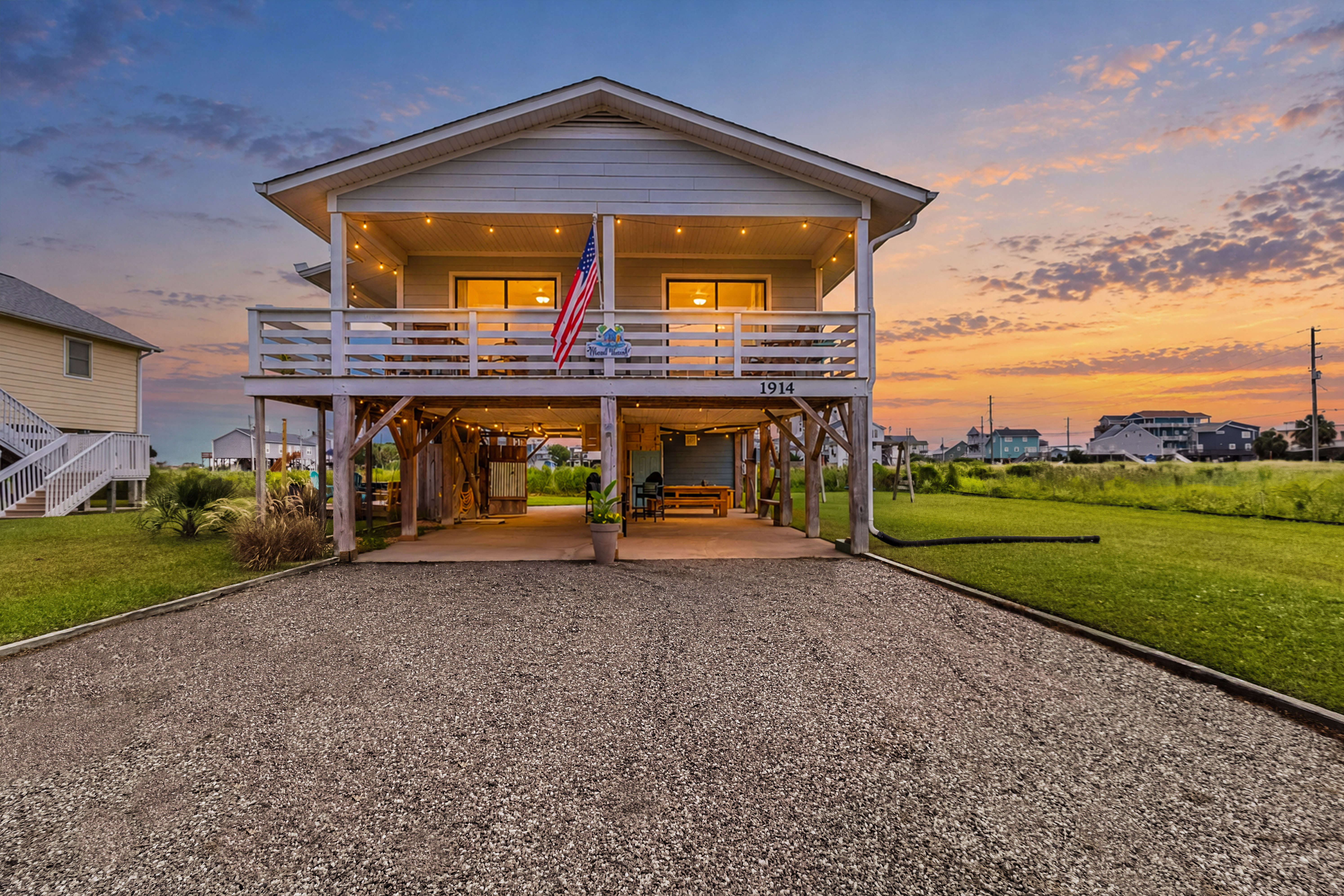 Charming elevated beach home with spacious driveway and sunset porch views