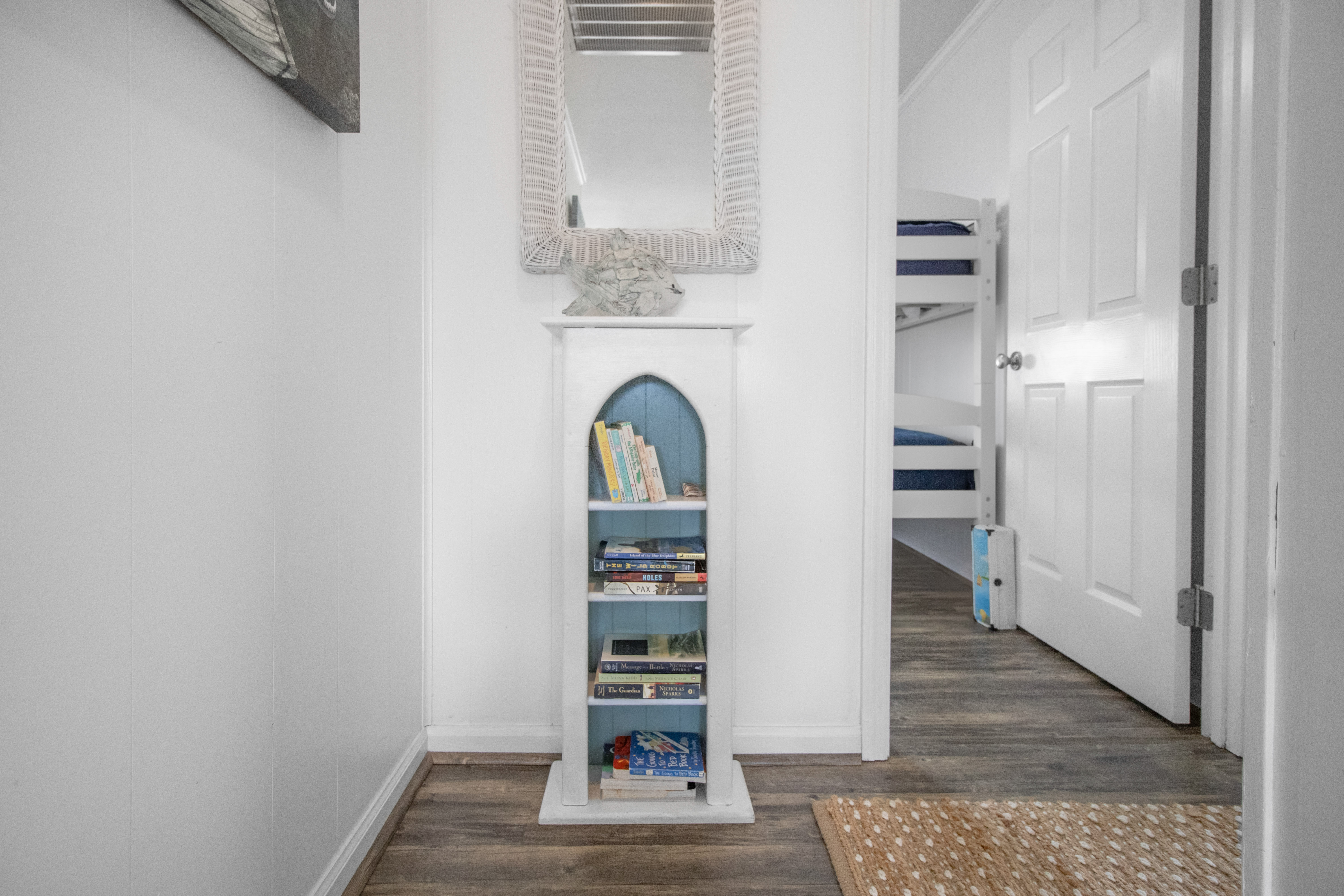Bright coastal hallway with games, books, and nearby bunk room