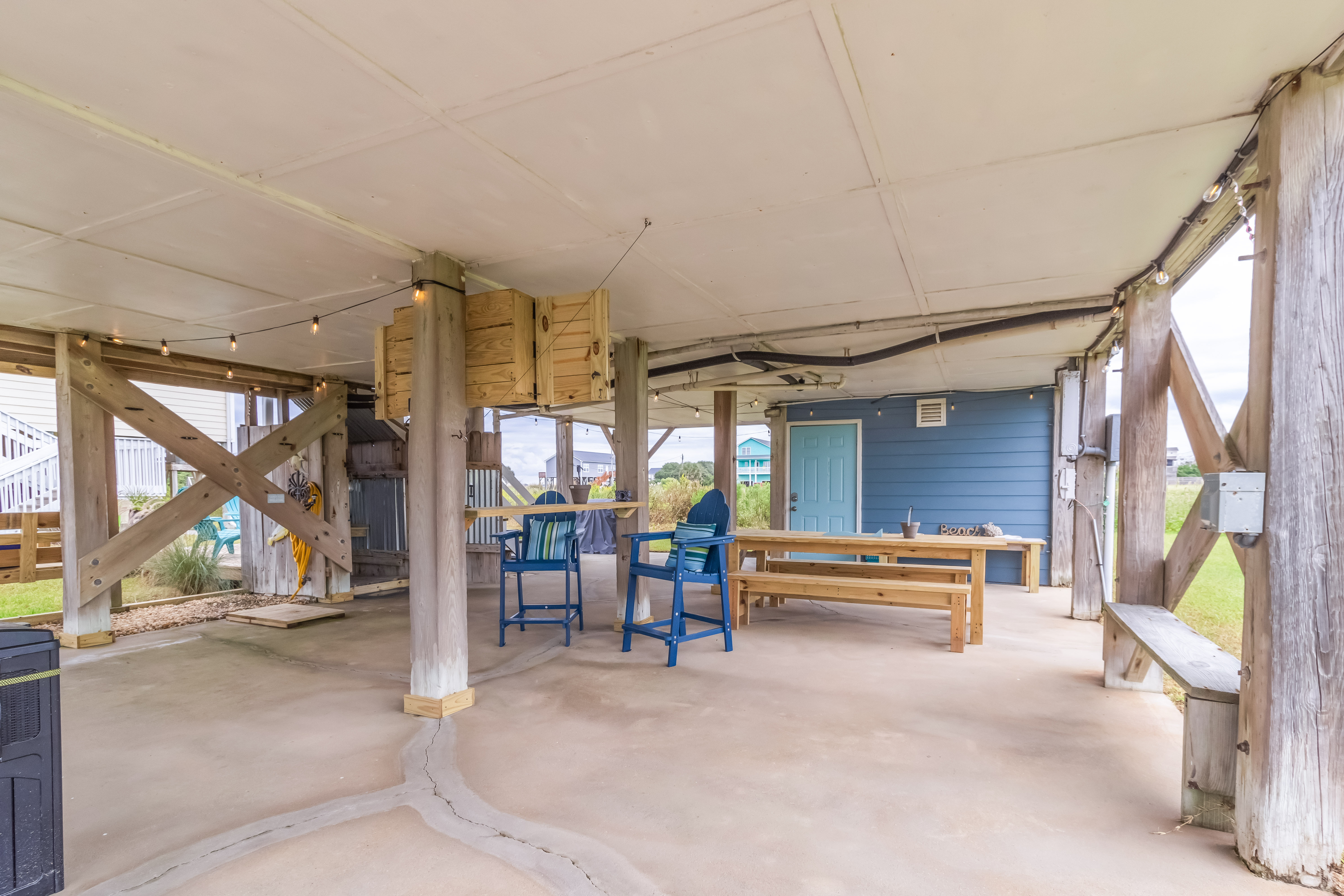 Covered outdoor hangout with dining space, bar seating, and coastal charm