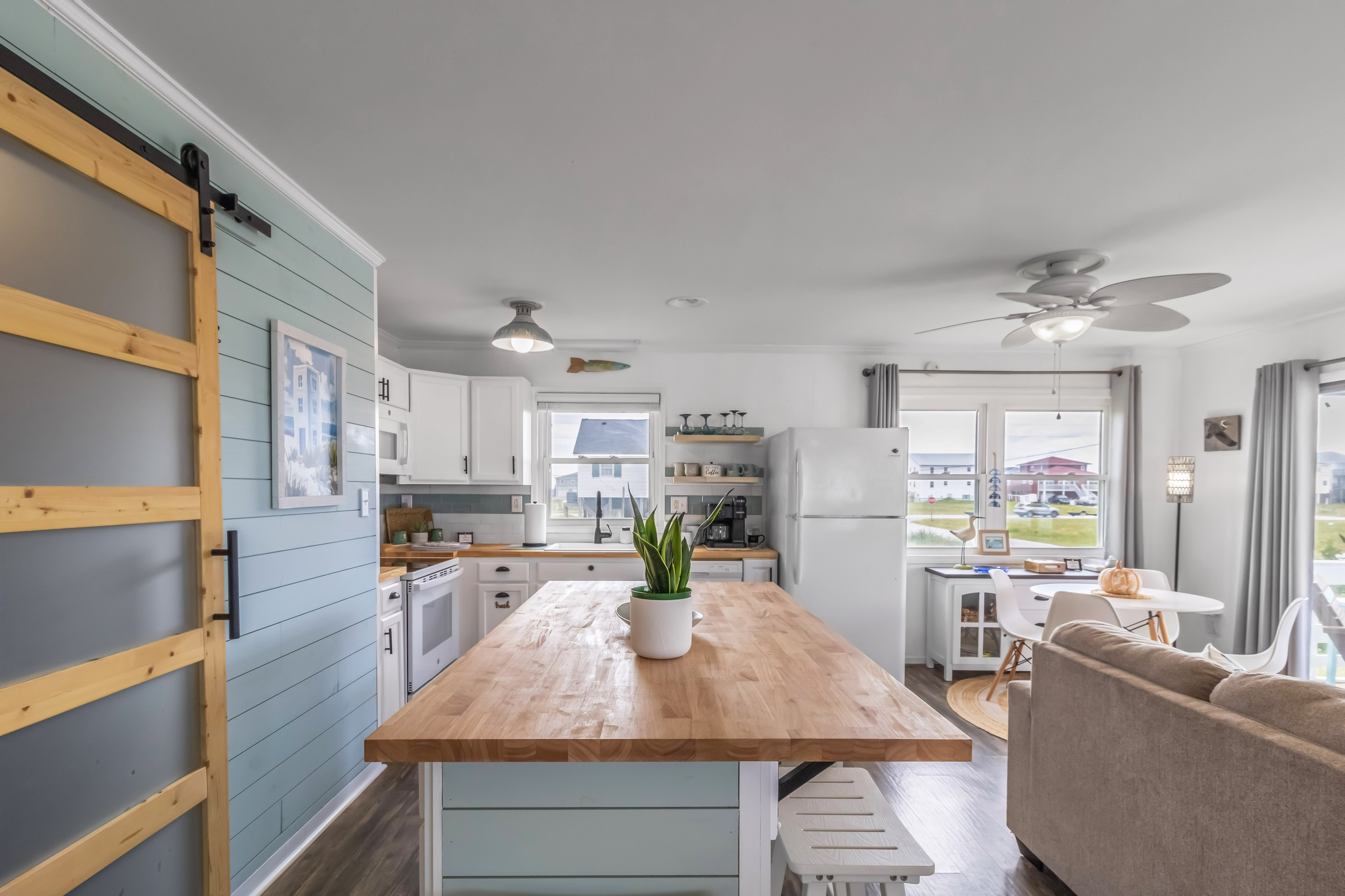 Bright coastal kitchen and living space with large island and sunny dining nook