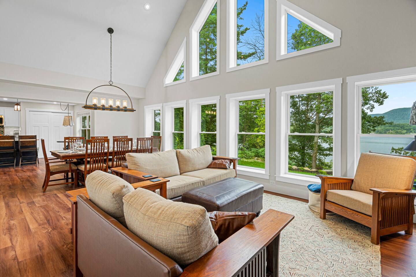 The Great Room with wall of windows boasts a stunning view and ample seating for relaxation and dining for large parties; the 8' sofa seats 4, the loveseat seats 2-3, and the ample chair holds an 8th person