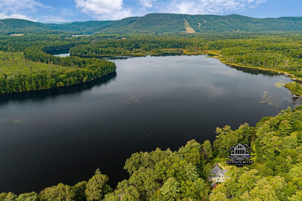 A daytime view of Hudson River Lodge, showing the bend in the Hudson River with West Mountain