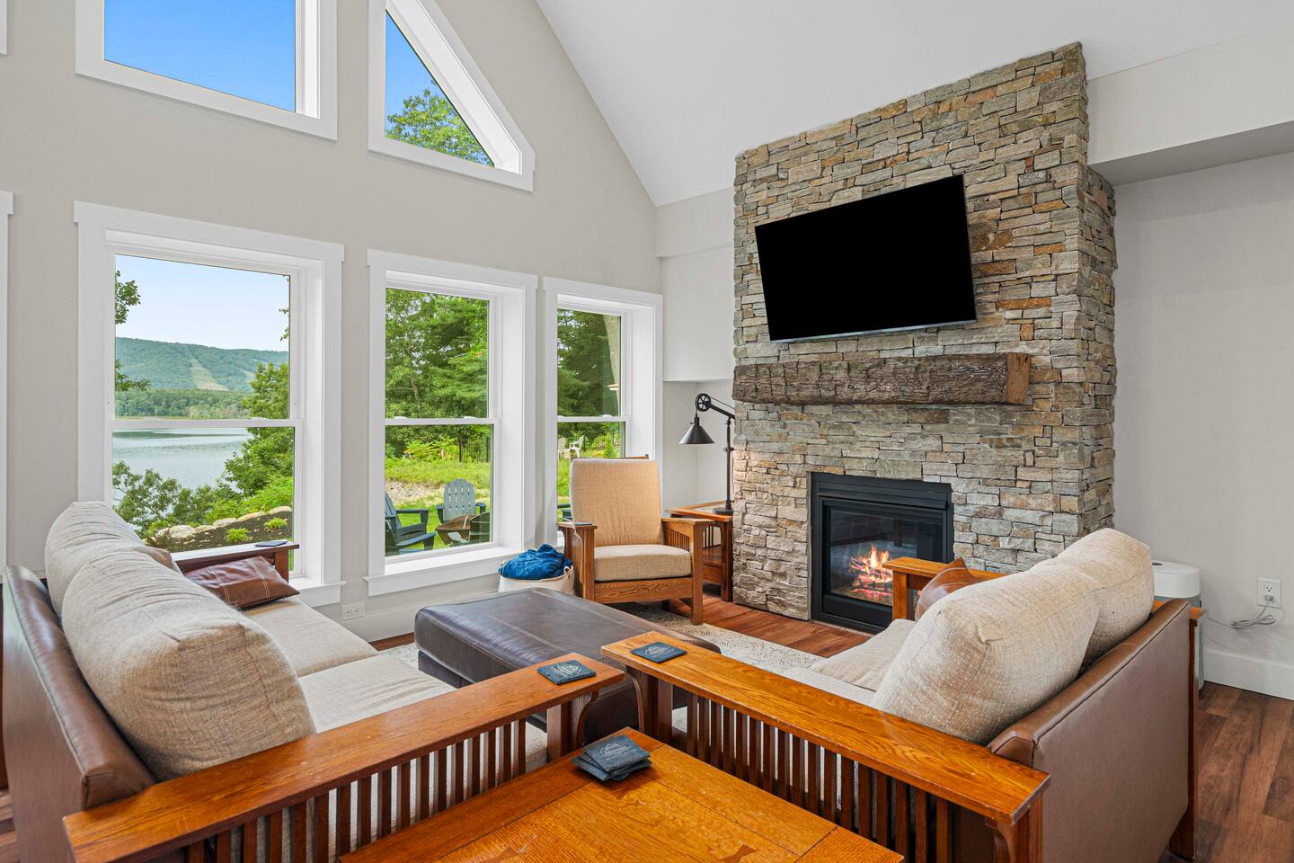 The full-height stone fireplace surrounds an authentic reclaimed beam from an Amish barn.  Curl up on the couch and get comfortable and cozy with the gas fireplace, tilting TV, and soft blankets while enjoying the view