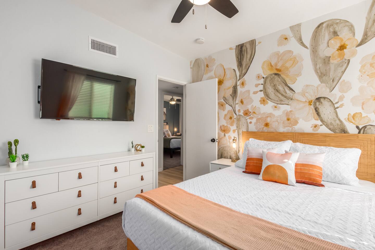 Cactus Room: Stylish and inviting, this bedroom features charming cactus wallpaper, a cozy queen bed, and a 55" TV for relaxing after a fun-filled day. A perfect blend of comfort and desert charm for a restful stay.