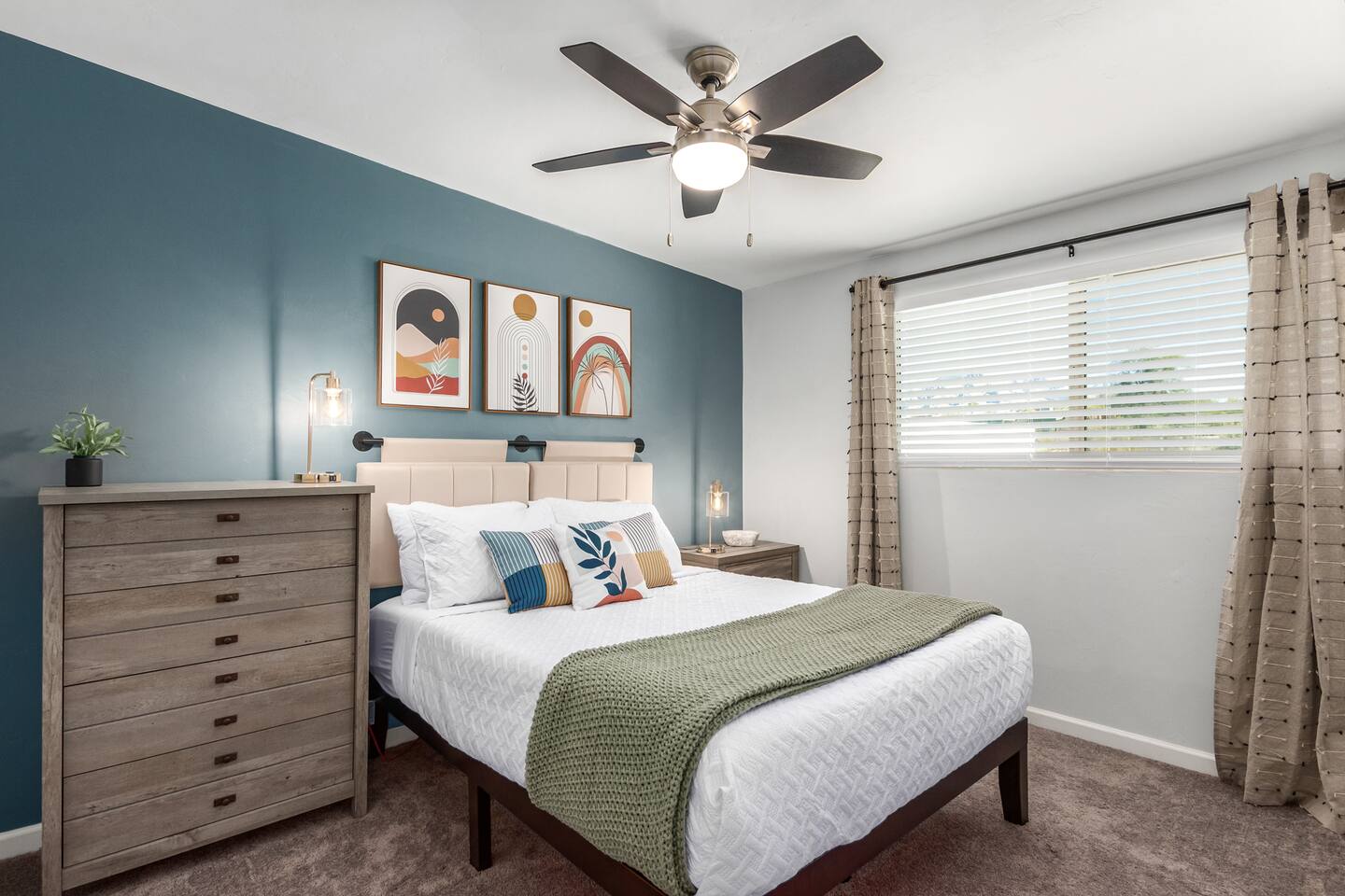 Drift into relaxation in this serene bedroom featuring a queen bed and calming blue accent wall—a peaceful retreat after a day of exploring.