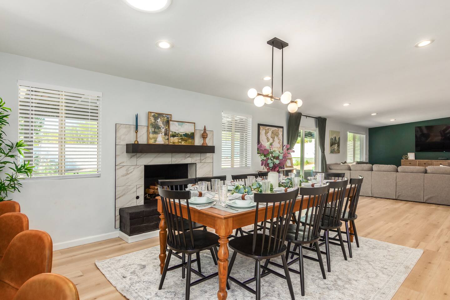 Gather around the large dining table with seating for eight, set beside a decorative fireplace—the perfect spot for shared meals and cozy evenings together.
