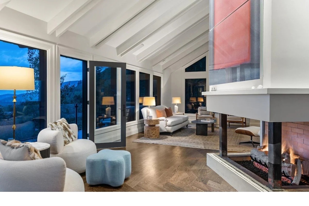 Stylish vaulted living room with fireplace and stunning view windows