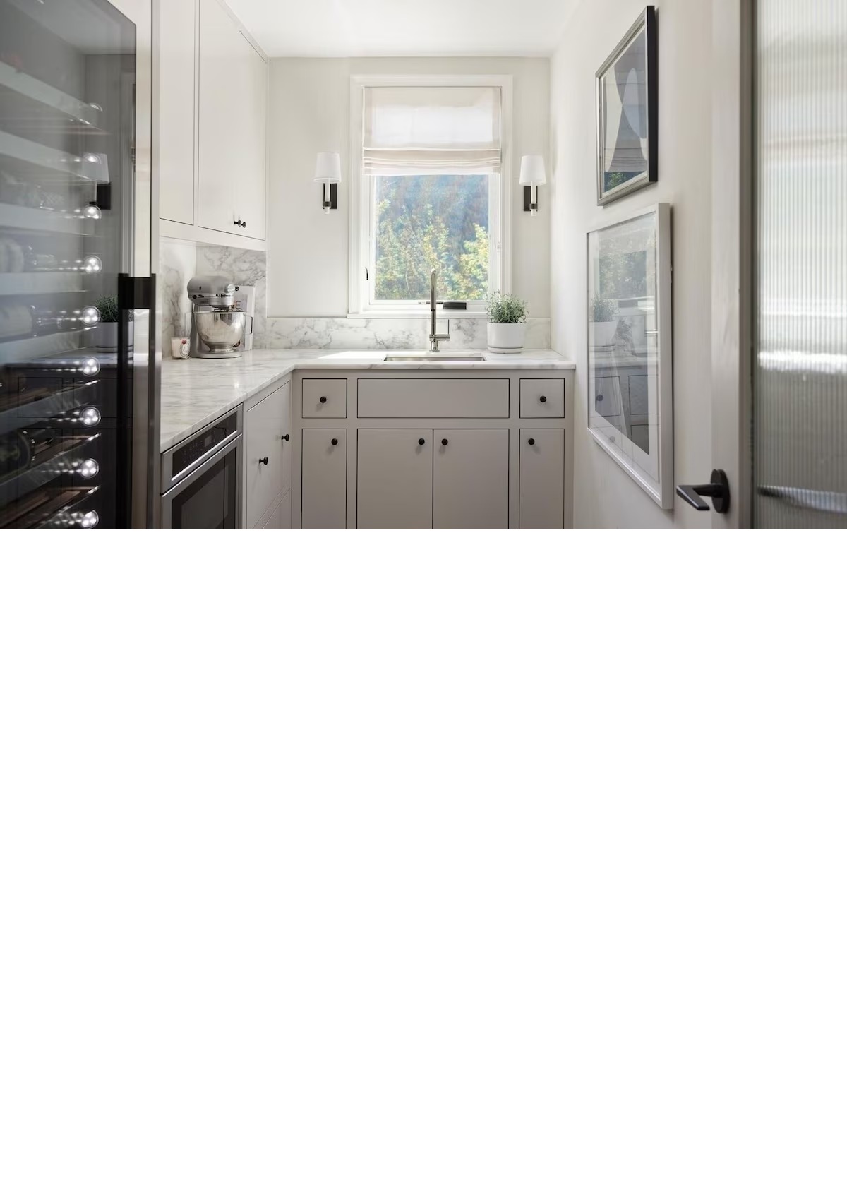 Bright butler’s pantry with wine fridge, prep sink, and marble counters