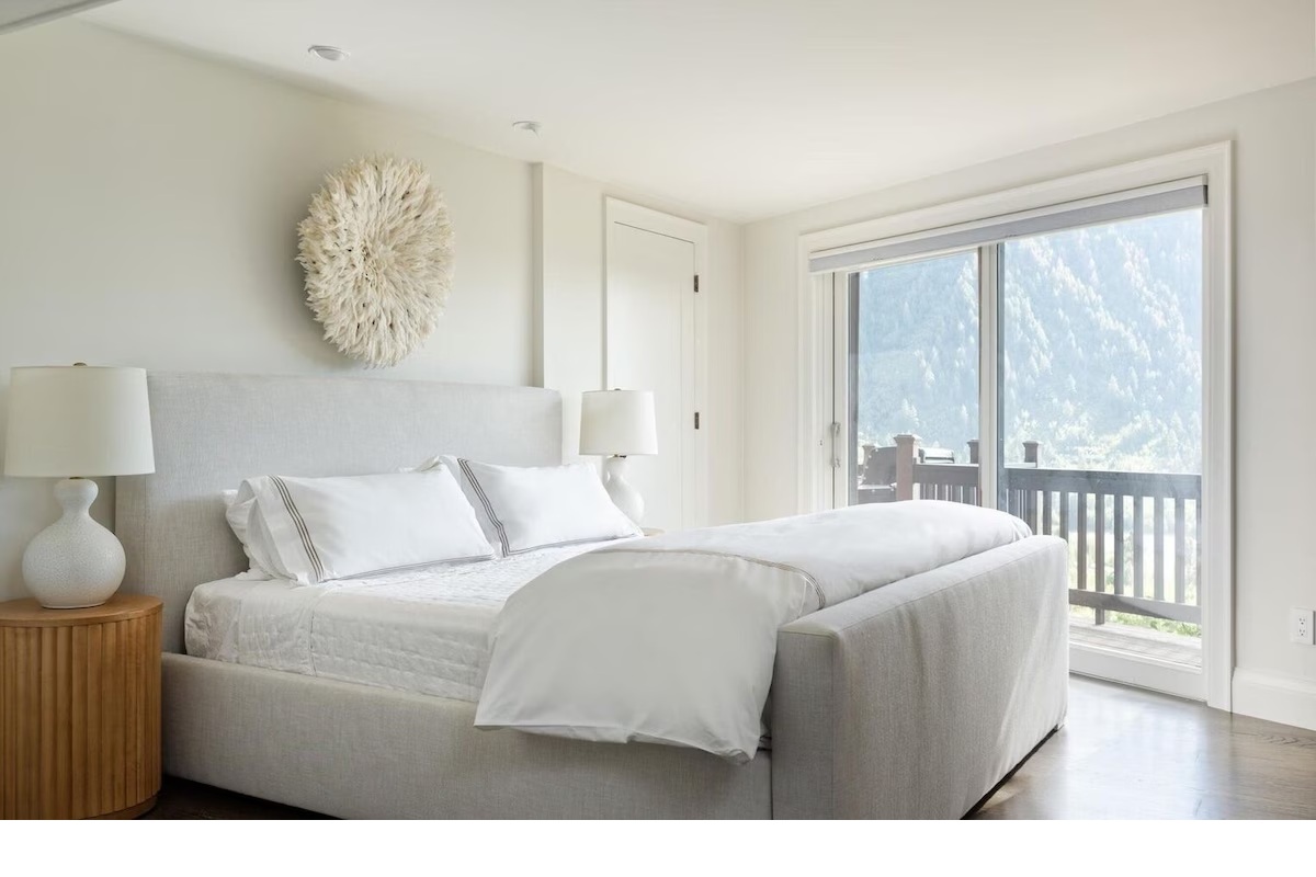 Bright mountain-view bedroom with private balcony and luxe linens