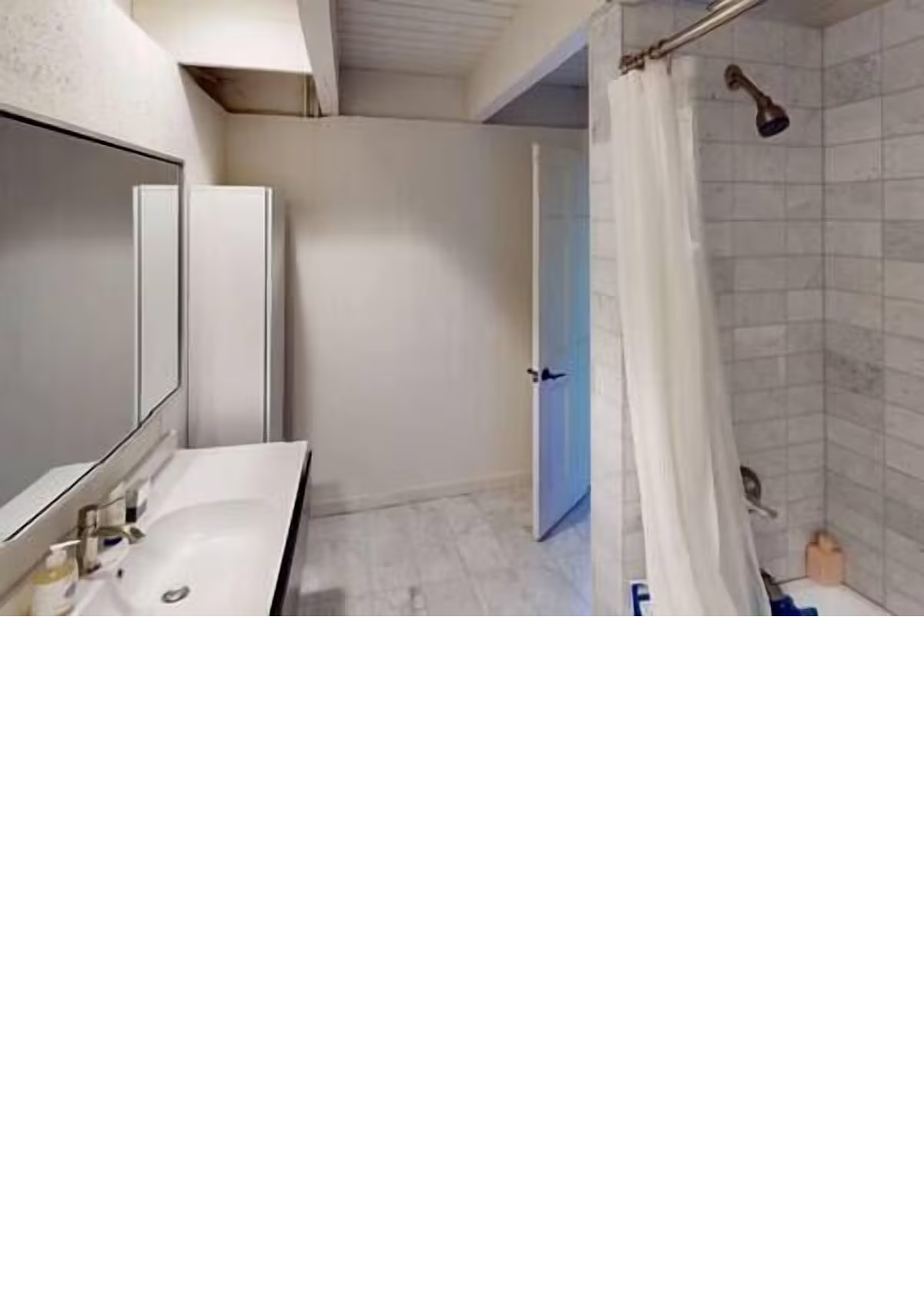 Bright, spacious bathroom with long vanity and tiled shower