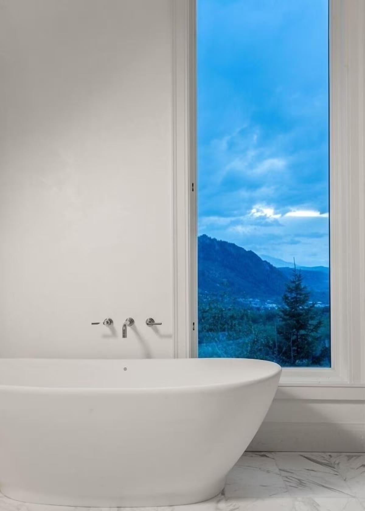 Spa-like soaking tub with breathtaking mountain-view window