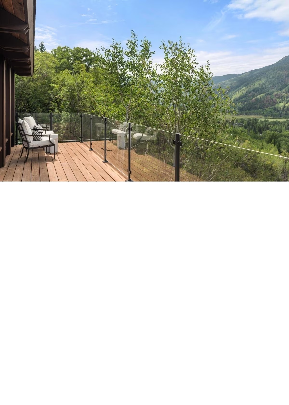 Scenic mountain-view deck with glass railing and relaxing outdoor seating
