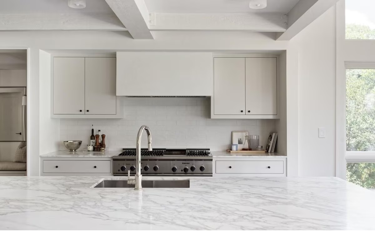 Bright designer kitchen with marble island and chef-style gas range