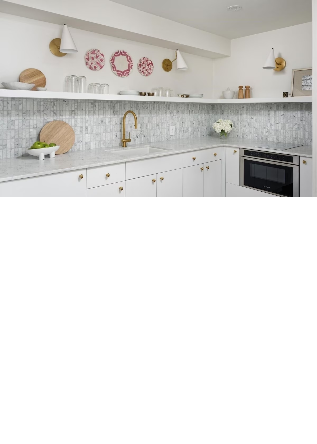 Bright modern kitchenette with marble finishes and elegant brass accents