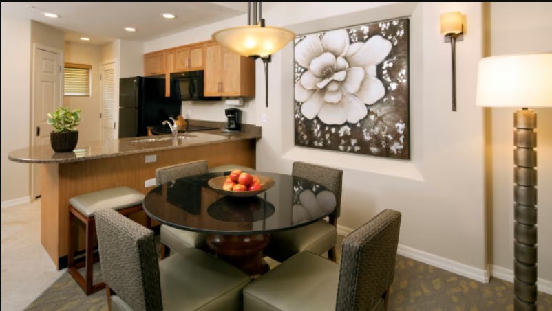 Elegant dining area with glass table and open kitchen breakfast bar