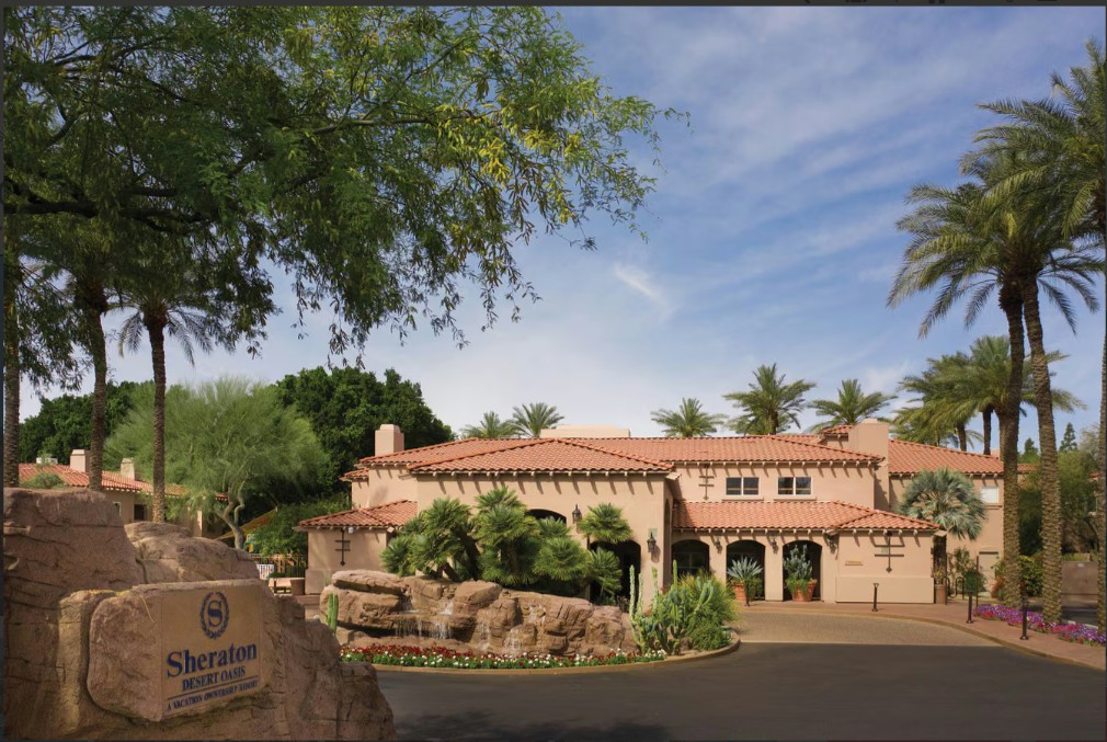 Resort-style desert entrance with palms, fountain, and elegant curb appeal