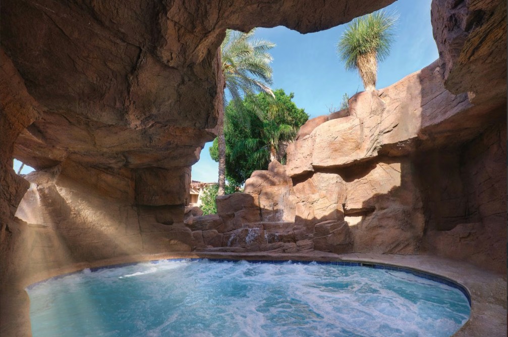 Private rock grotto spa with bubbling water and tropical oasis vibes