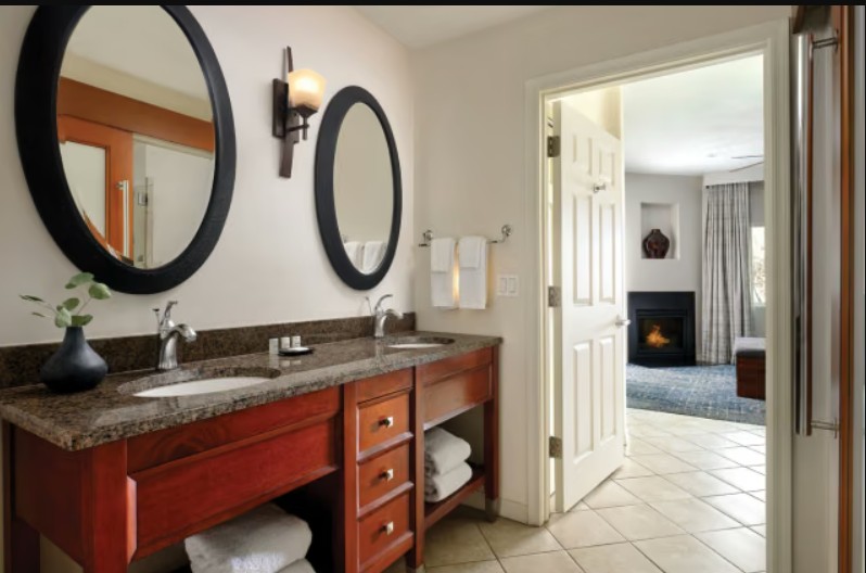 Spacious double vanity bath with granite counters and cozy suite fireplace views