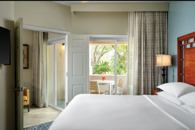 Bright king bedroom with private patio and tropical garden views