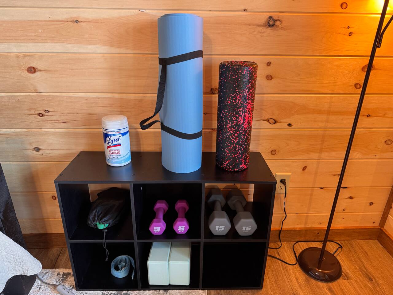 Workout equipment including yoga mat, yoga blocks, foam roller, assorted weights, and bands provided.